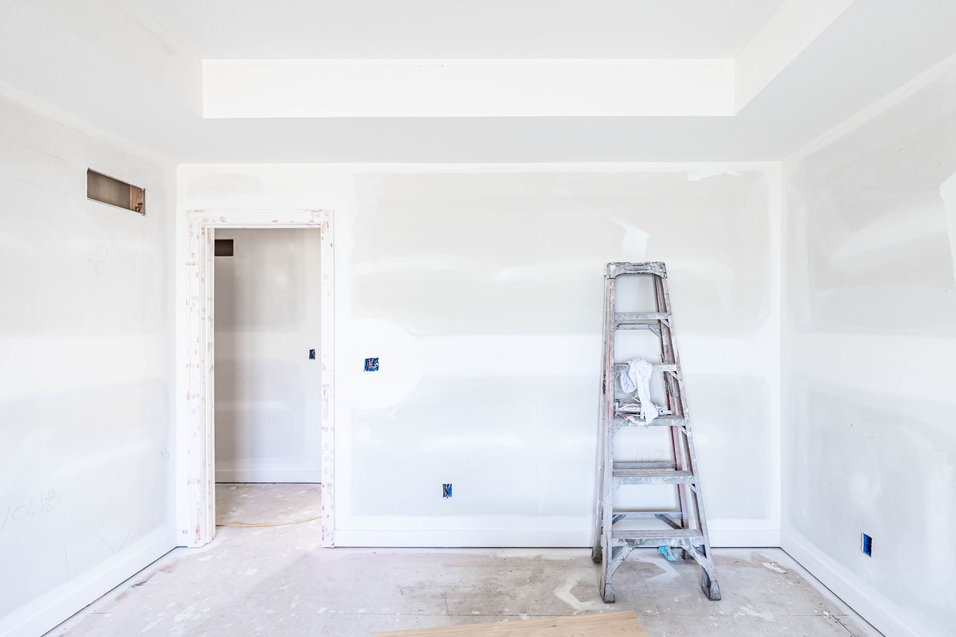 Interior room under construction with a ladder and unfinished walls.