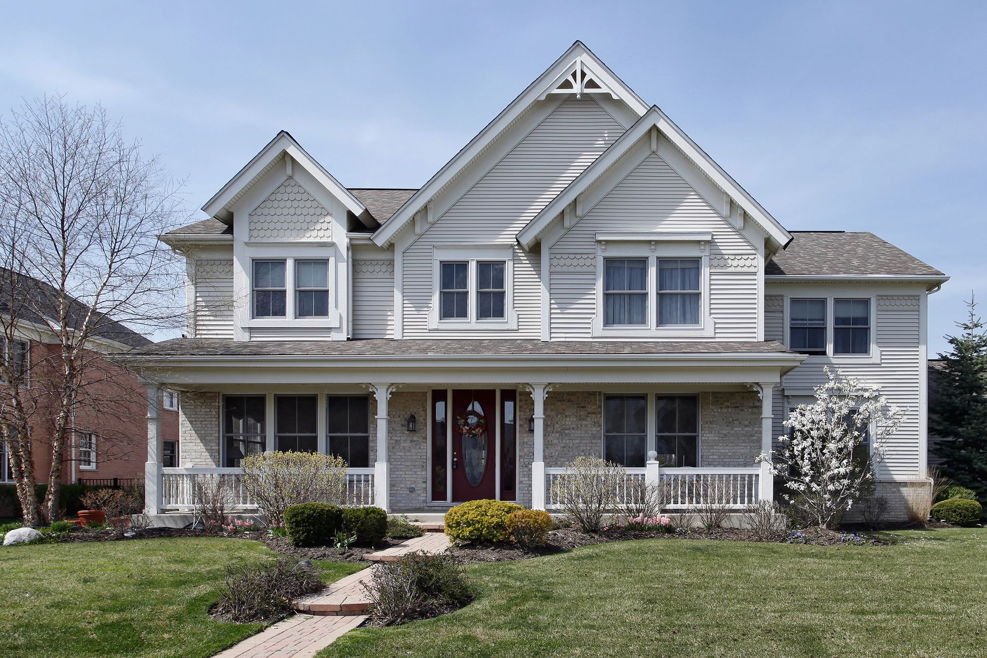 A large white house with a red door and porch