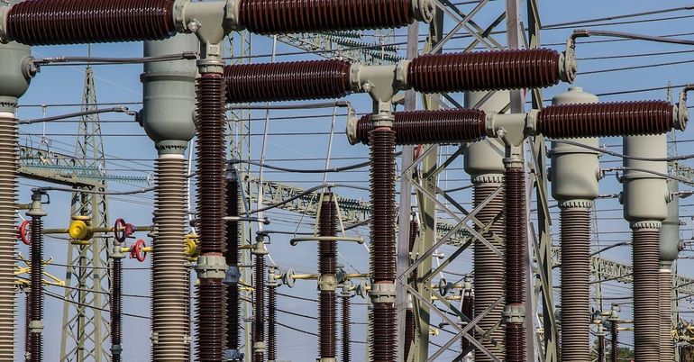 A row of electrical transformers are lined up in a power station.