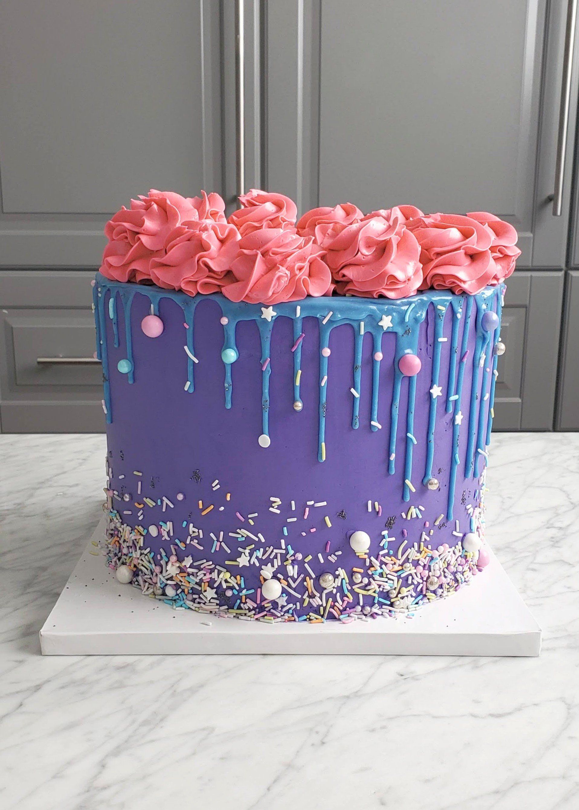 purple cake with sprinkles and pink icing