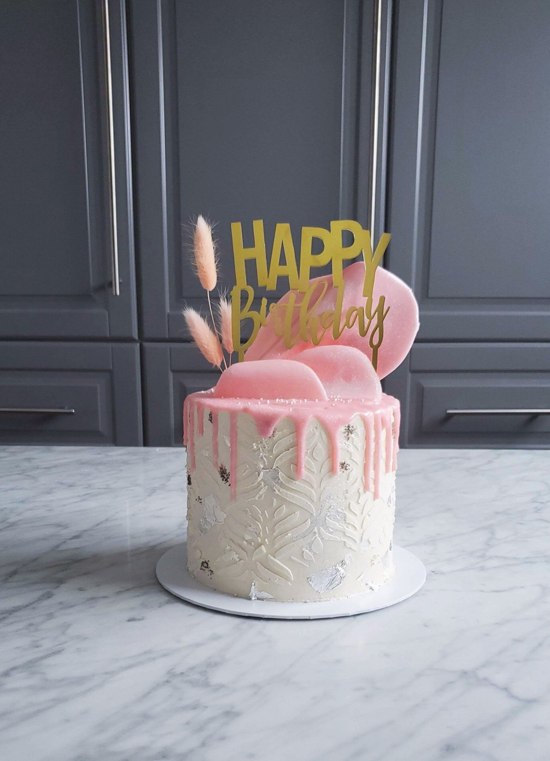 pink boho cake with stencil pattern, topper, and decorations