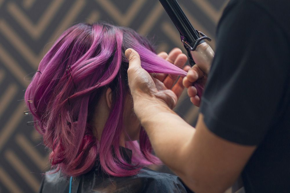 A Woman With Purple Hair Is Getting Her Hair Done By A Hairdresser — L'Auranda Hair Salon In Evan St. Mackay, QLD