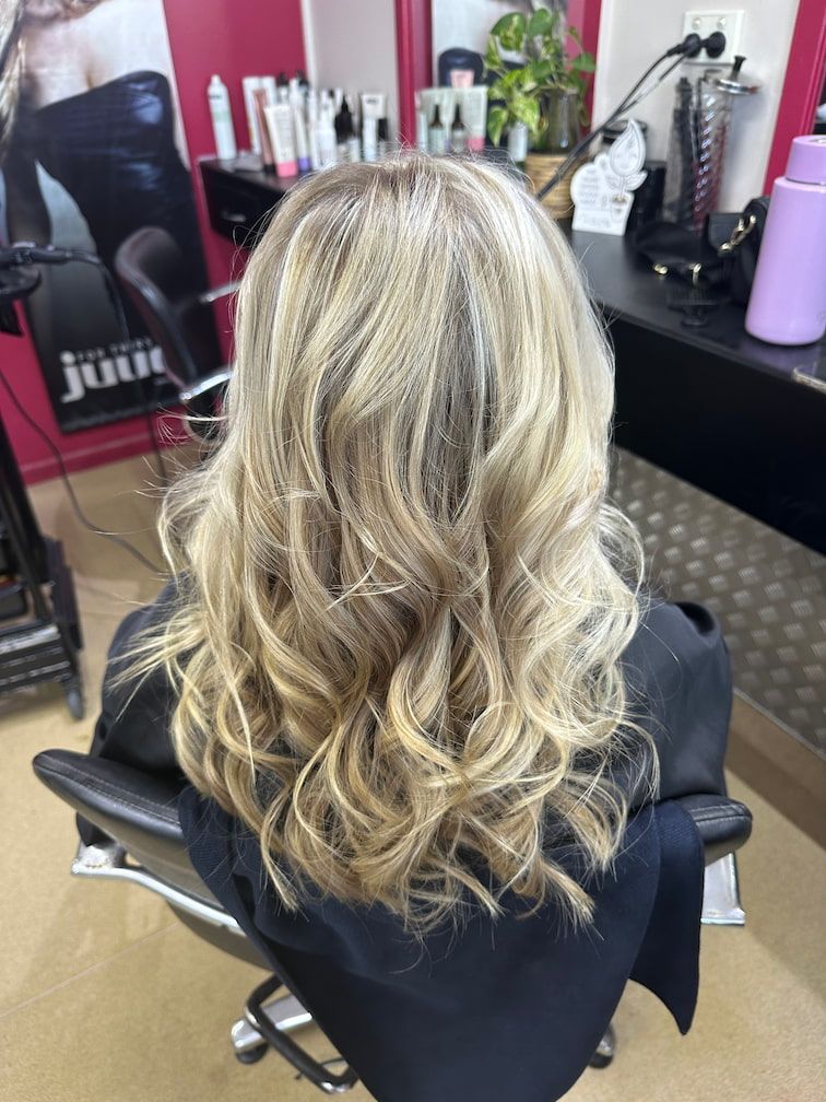 A Woman With Long Wavy Blonde Hair Has Had Highlights In A Salon — L'Auranda Hair Salon In Evan St. Mackay, QLD