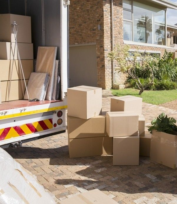 A Movers Unloading a Sofa and Boxes from A Truck — Brett Cooper Removals Hervey Bay in Urangan, QLD