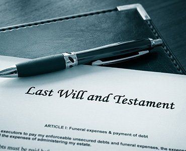 Last Will and Testament document with a pen, resting on a leather surface.