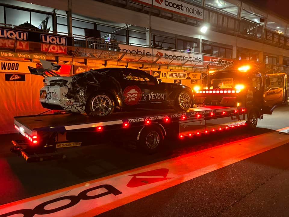 A Car is Being Towed by a Tow Truck at Night — Trade & General Towing in Rutherford, NSW