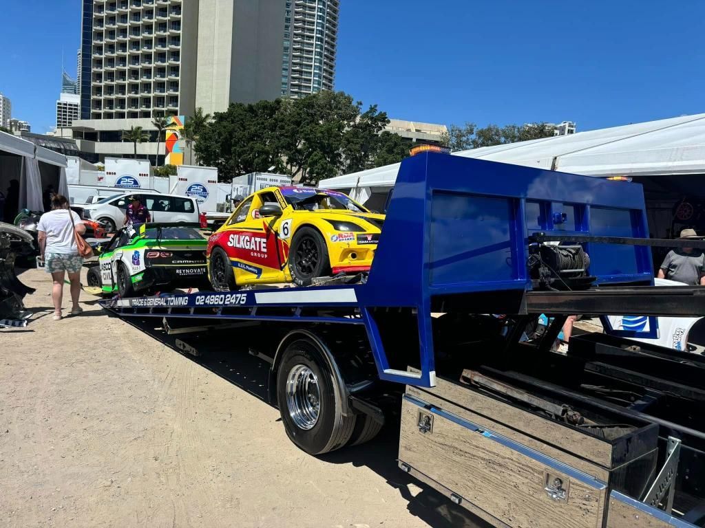 A Tow Truck is Carrying a Race Car on the Back of It — Trade & General Towing in Singleton, NSW