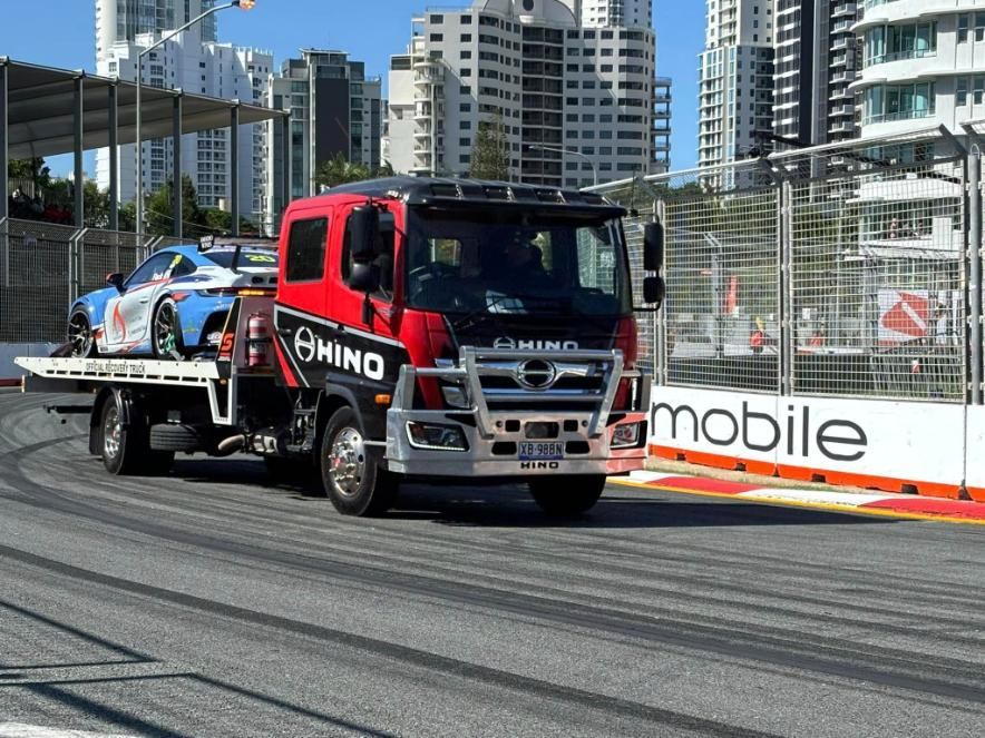 A Tow Truck is Carrying a Car on a Race Track — Trade & General Towing in Wyong, NSW