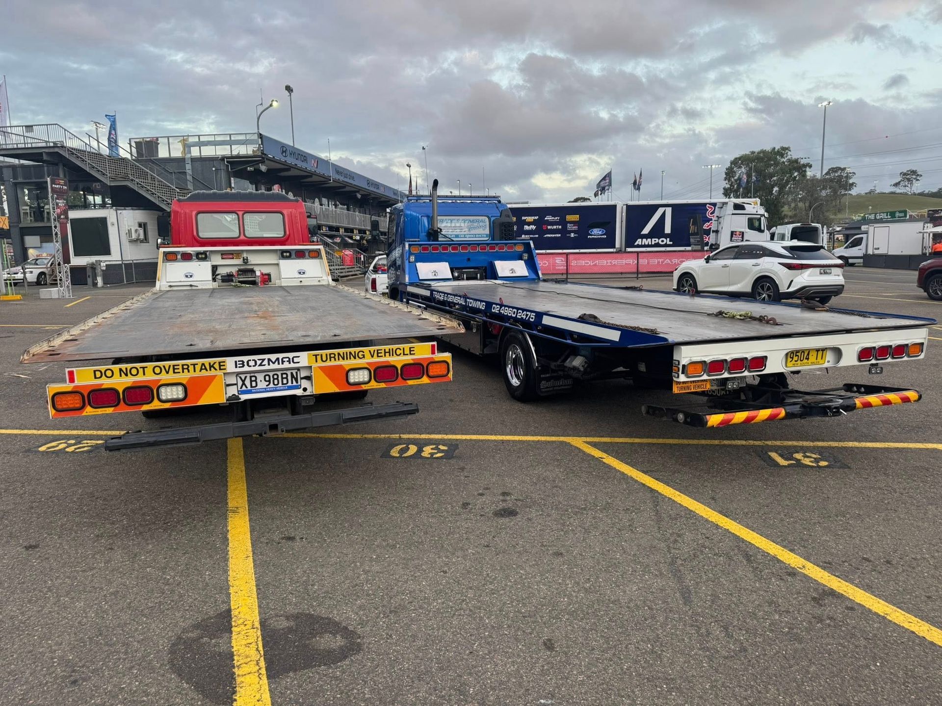 Two Flatbed Tow Trucks Red And Blue Parked
