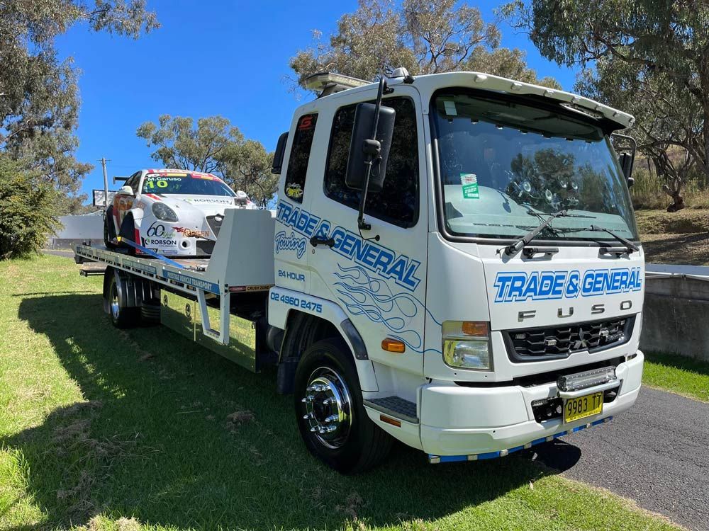 Fuso Towing Car With Racing Car — Trade & General Towing in Sandgate, NSW
