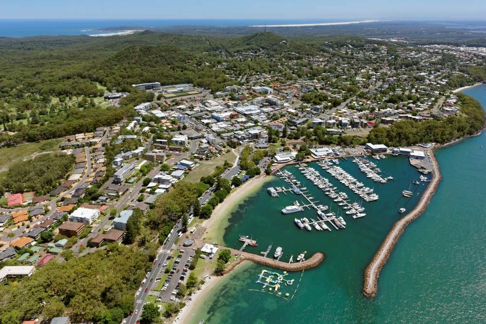An Aerial View of a Harbor With Boats Docked and a City in the Background — Trade & General Towing in Nelson Bay, NSW