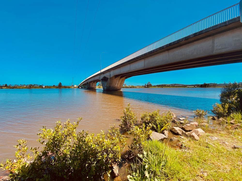 A Bridge Over a Body of Water With a Blue Sky in the Background — Trade & General Towing in Raymond Terrace, NSW