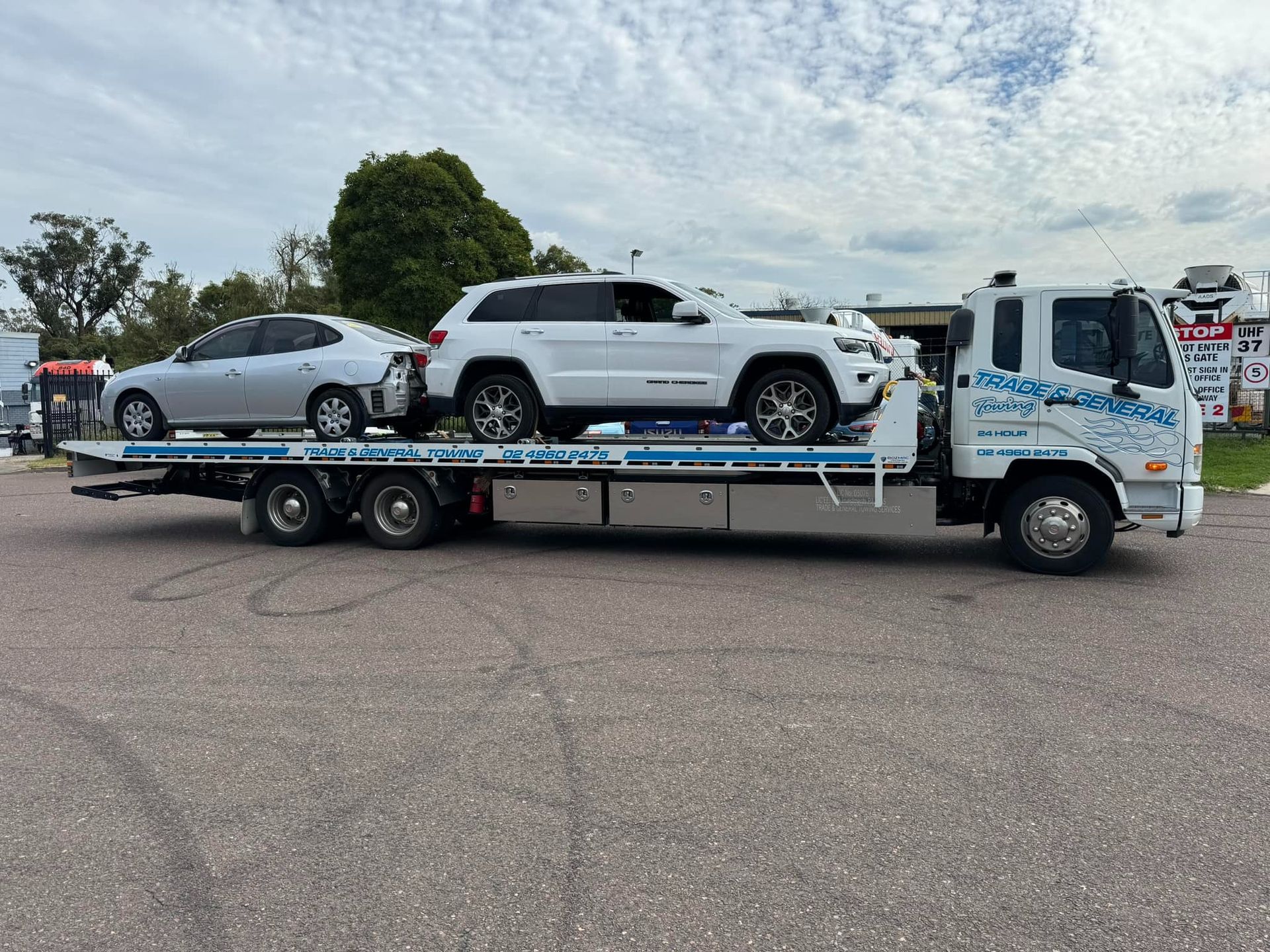 Tow Truck Carrying Silver and White Suvs