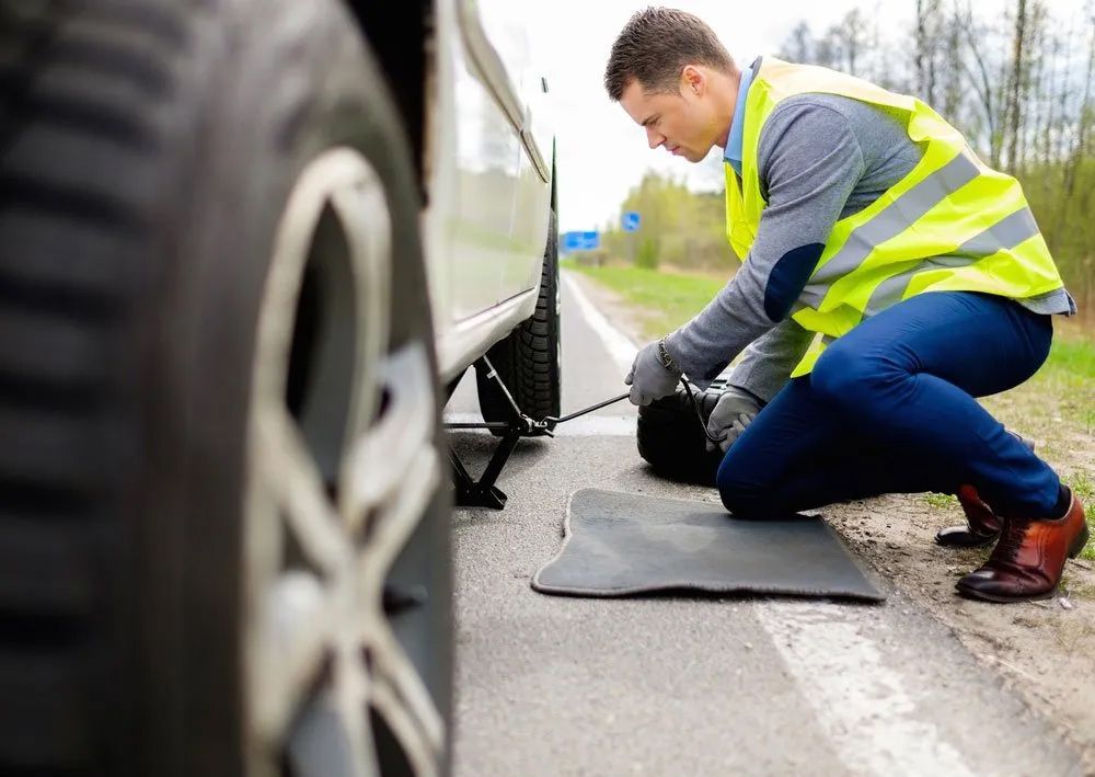 Man Changing Wheel Roadside — Trade & General Towing In Sandgate NSW