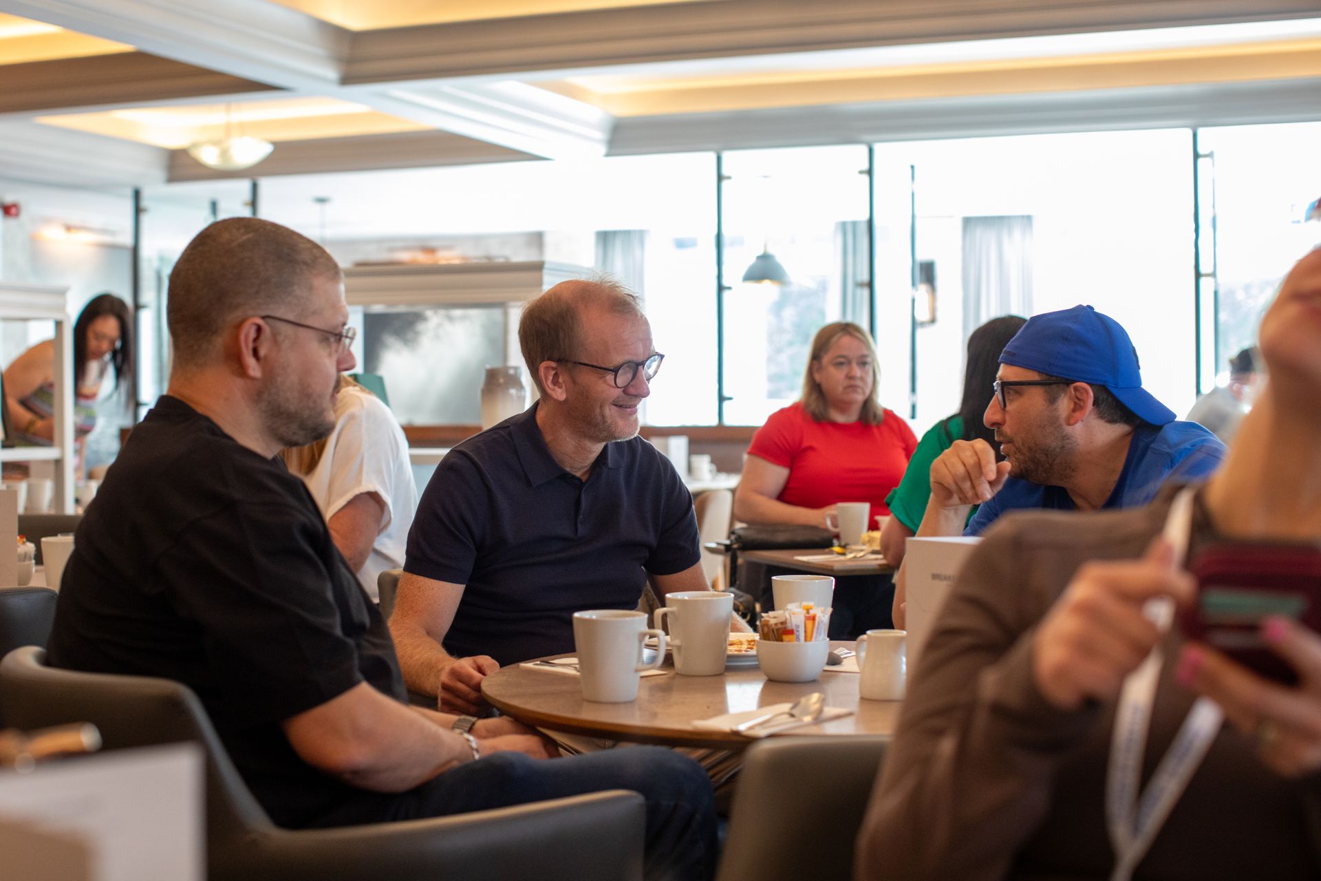 A group of people are sitting at tables in a restaurant.