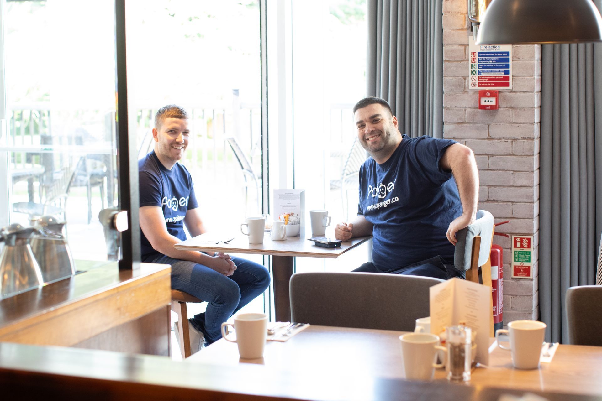 Two men are sitting at a table in a restaurant.