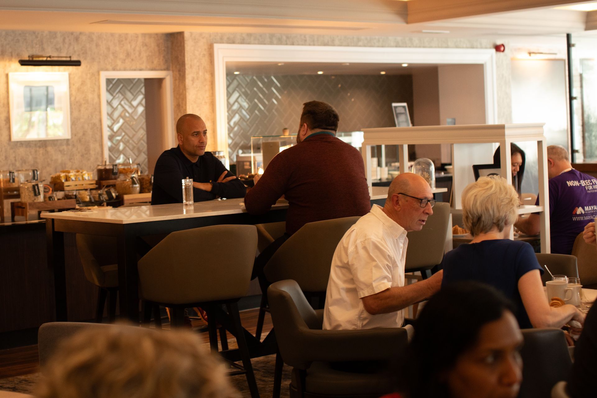 A group of people are sitting at tables in a restaurant.