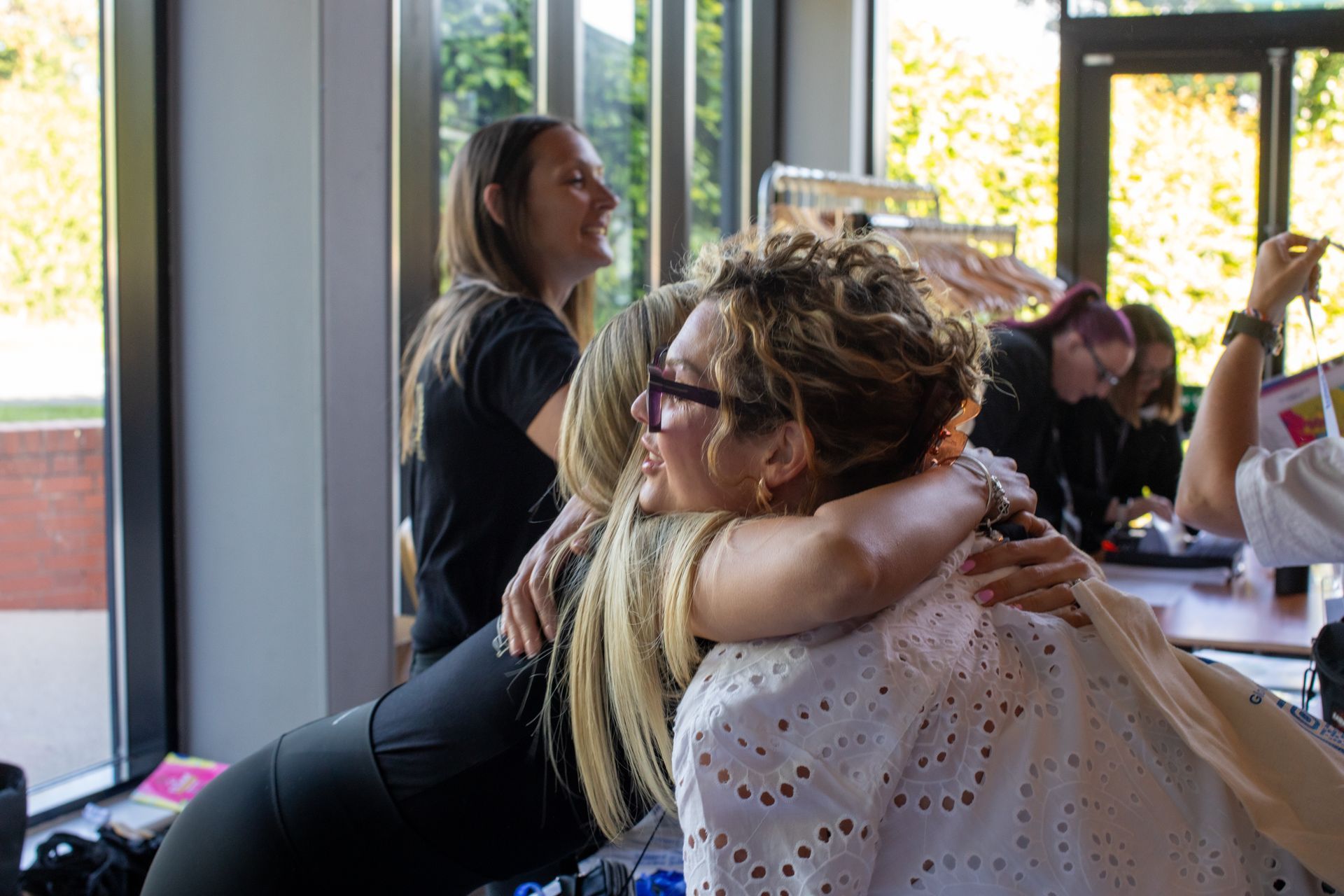 A group of women are hugging each other in a room.