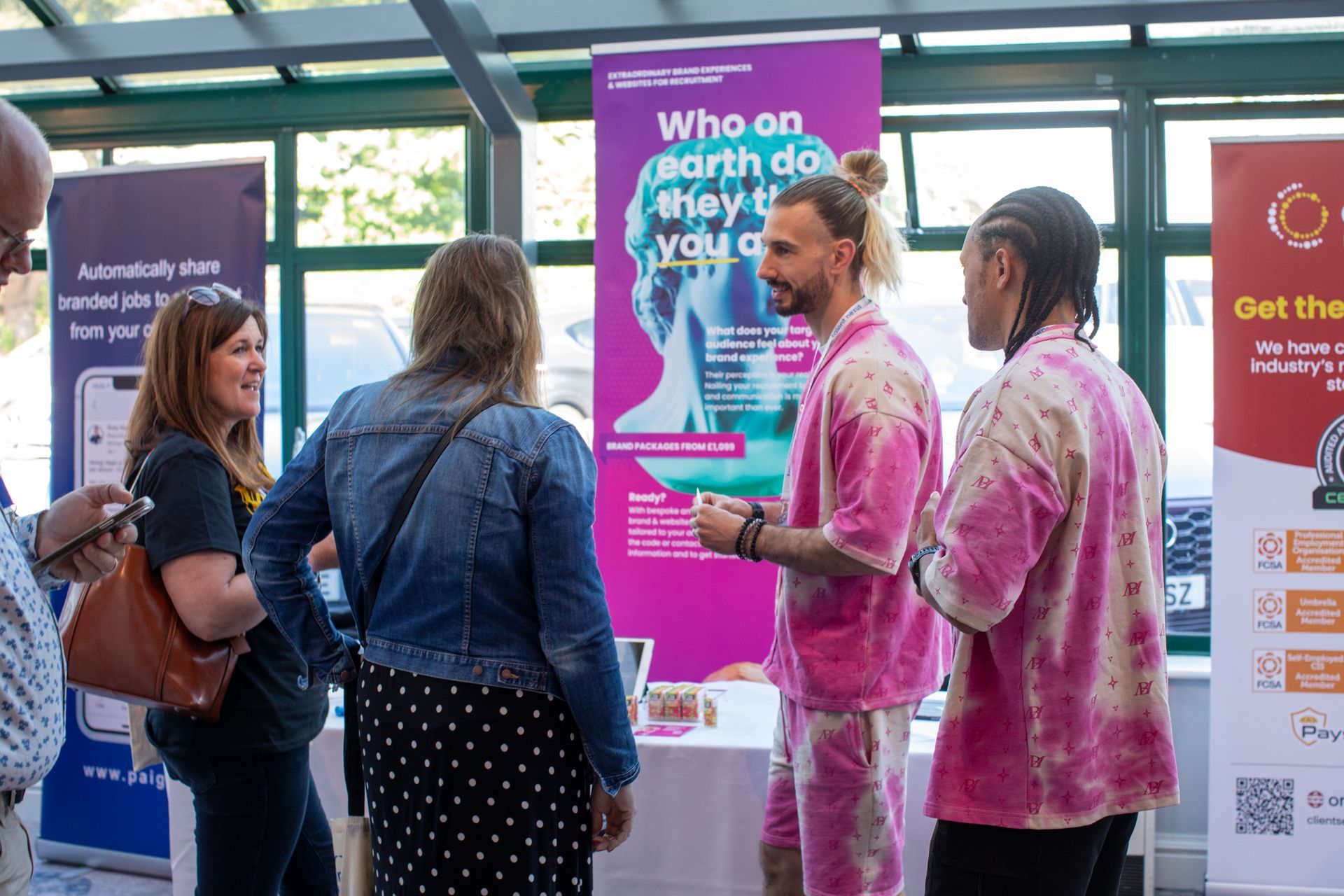 A group of people are standing around a table at a convention.