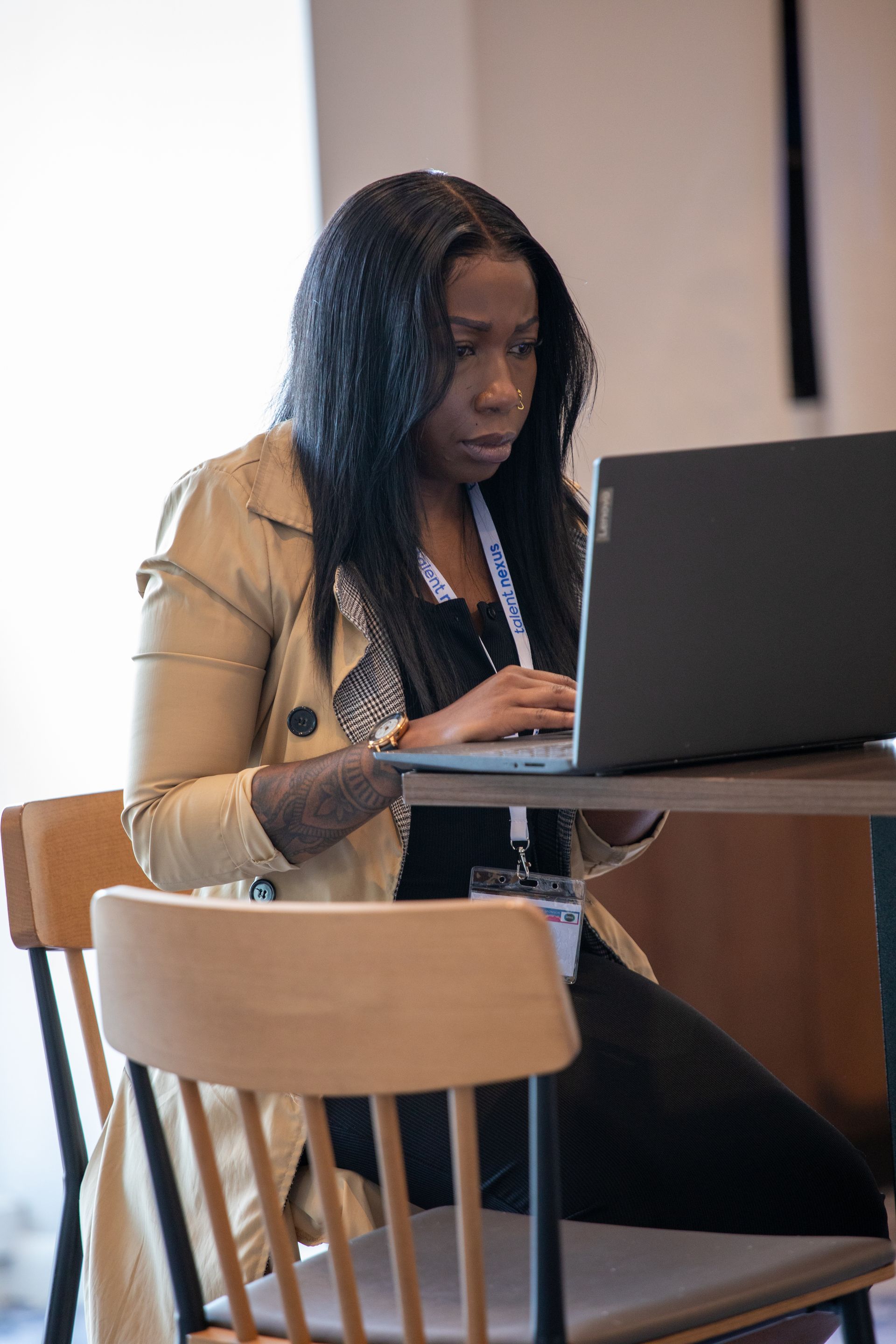 A woman is sitting at a table using a laptop computer.