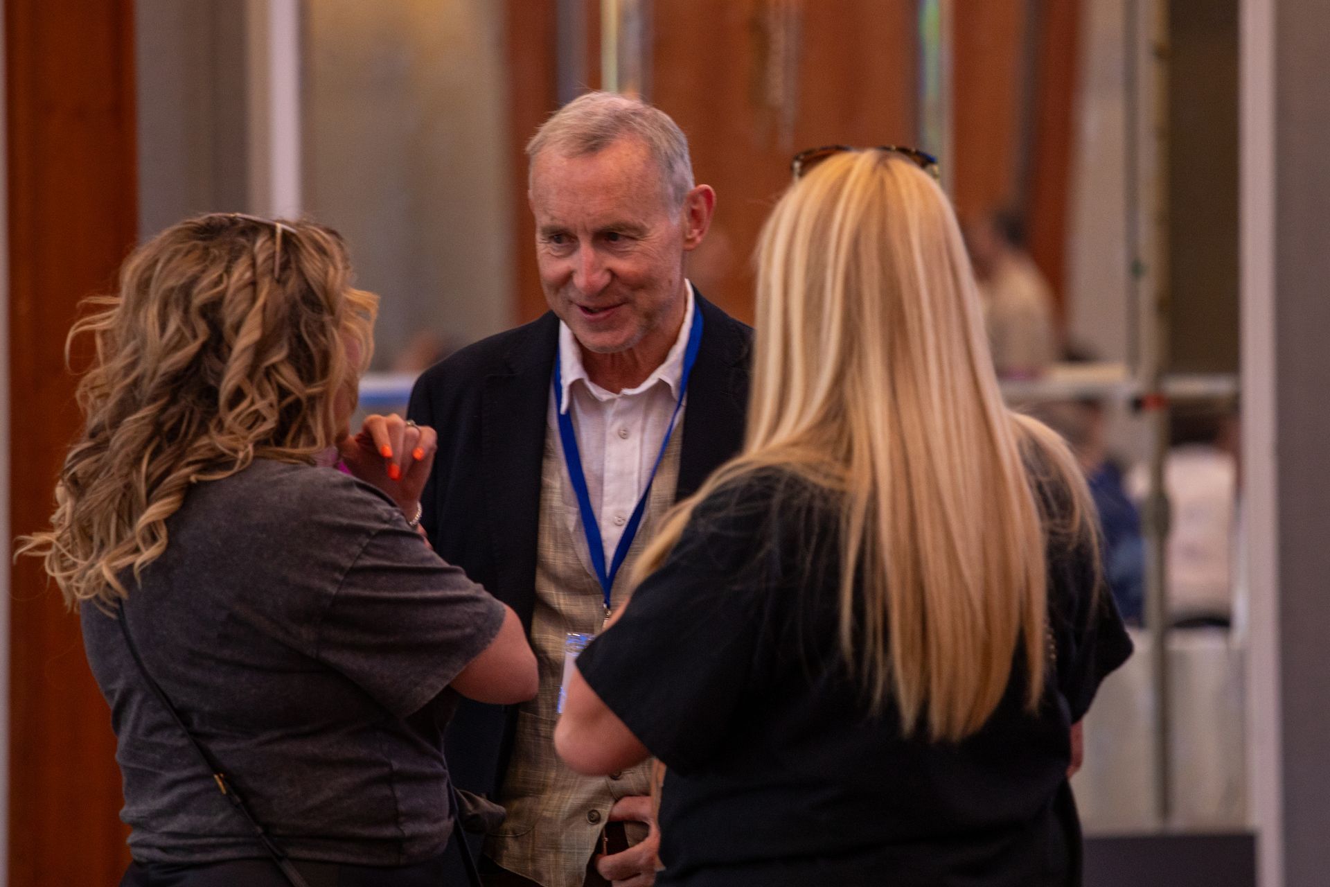 A man and two women are talking to each other in a room.