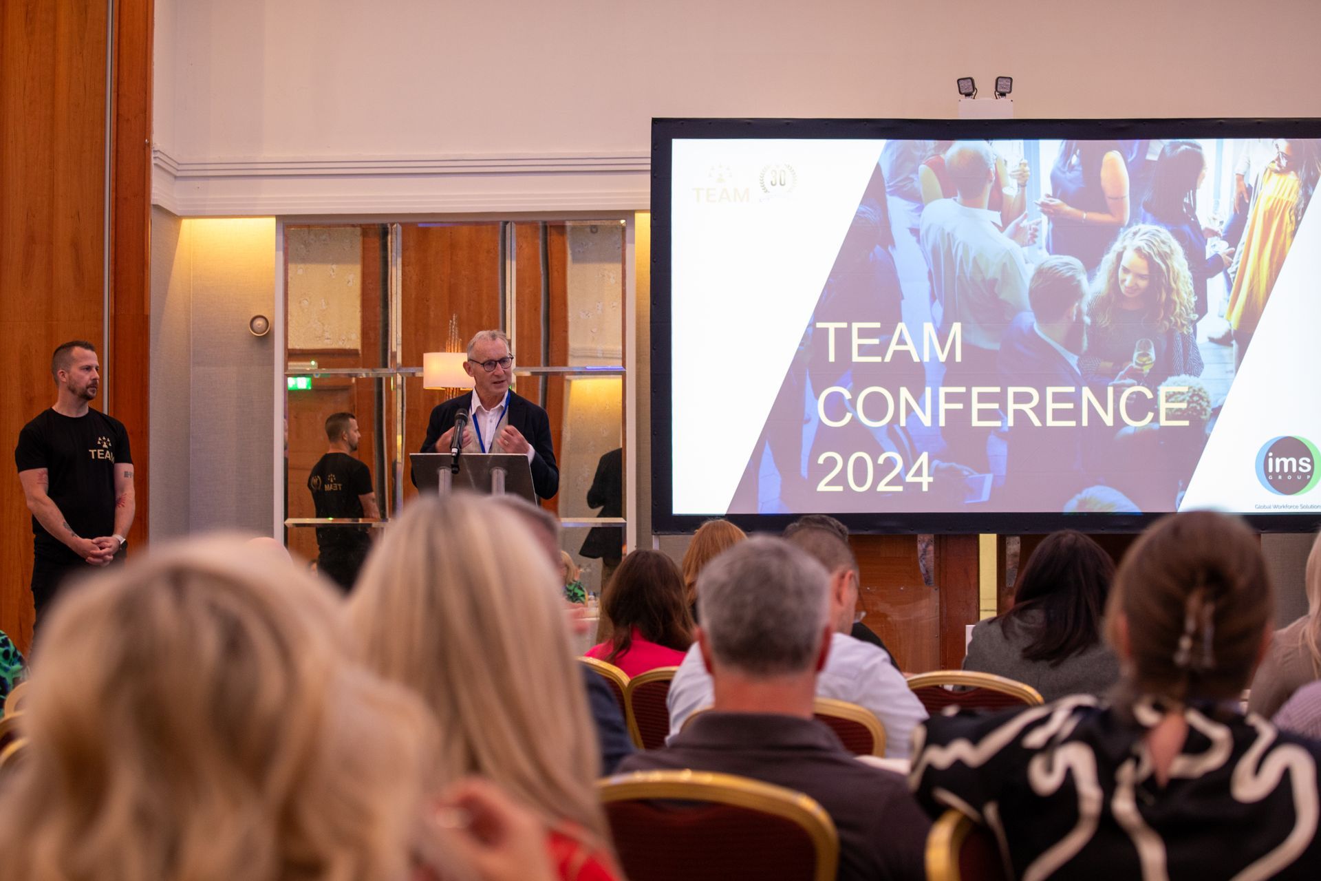 A man is giving a presentation at a team conference.
