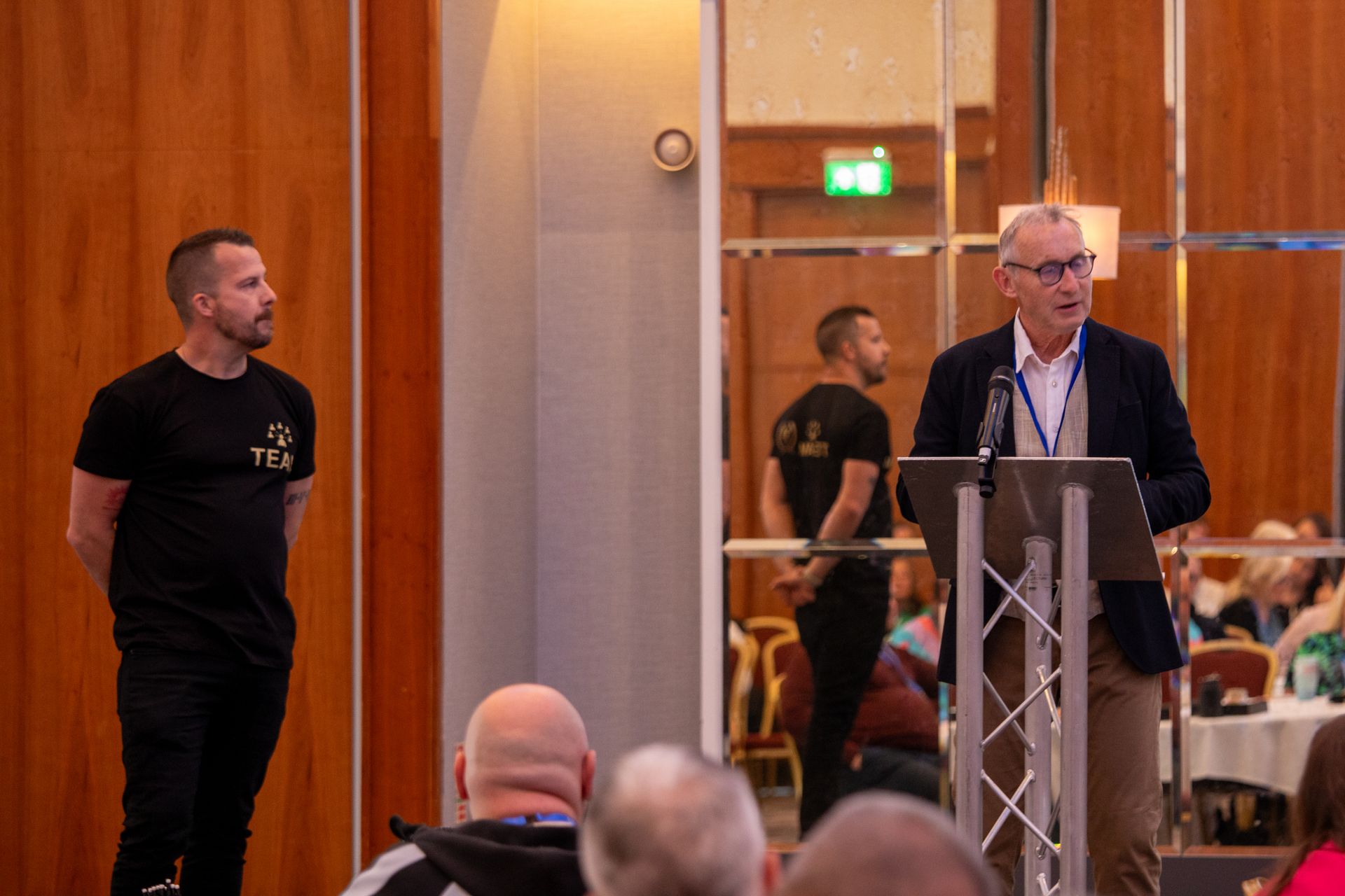 A man is standing at a podium giving a presentation to a group of people.