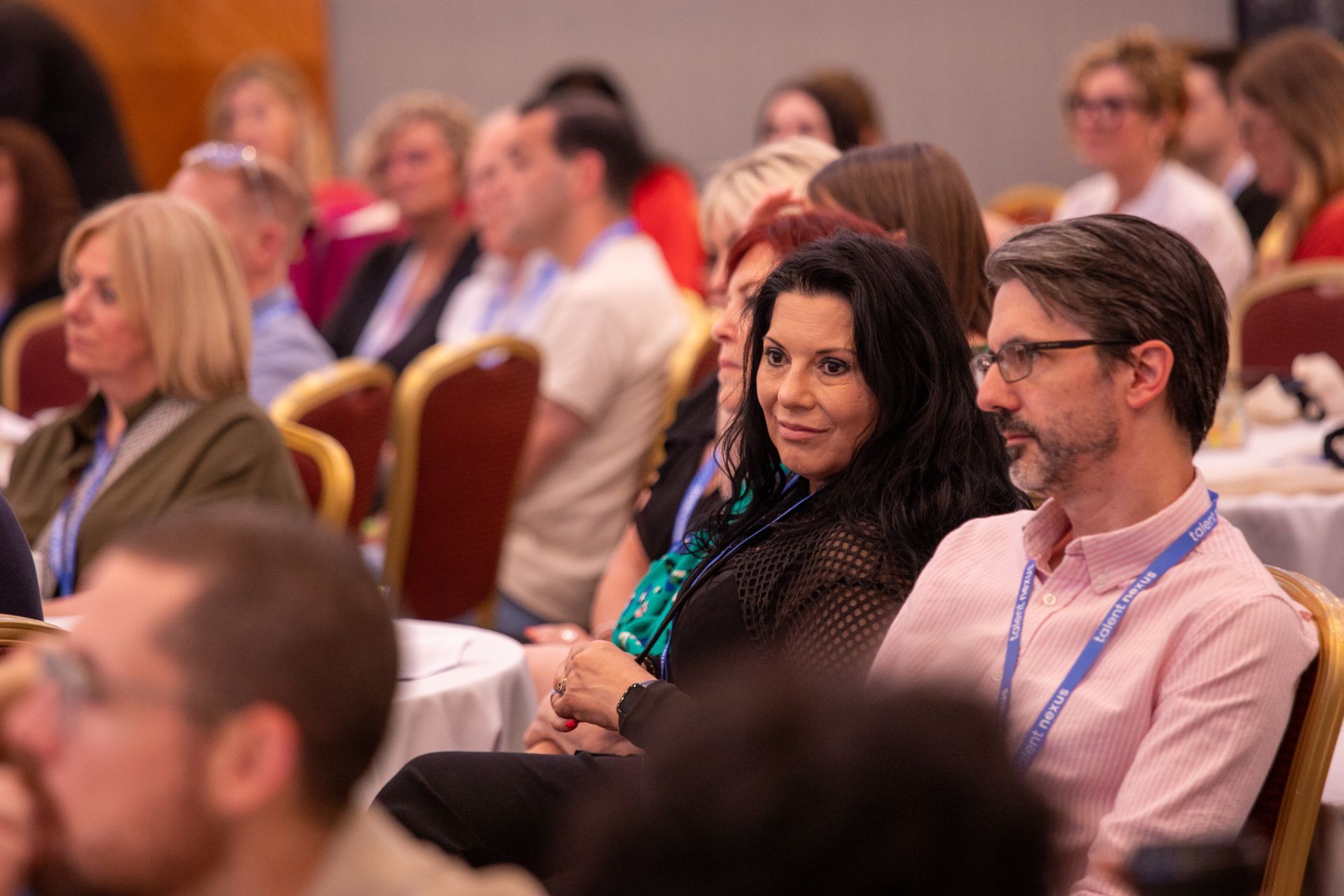 A group of people are sitting in chairs at a conference.