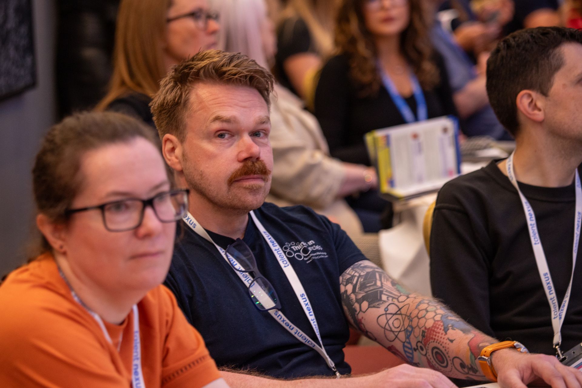 A group of people are sitting in a room watching a presentation.