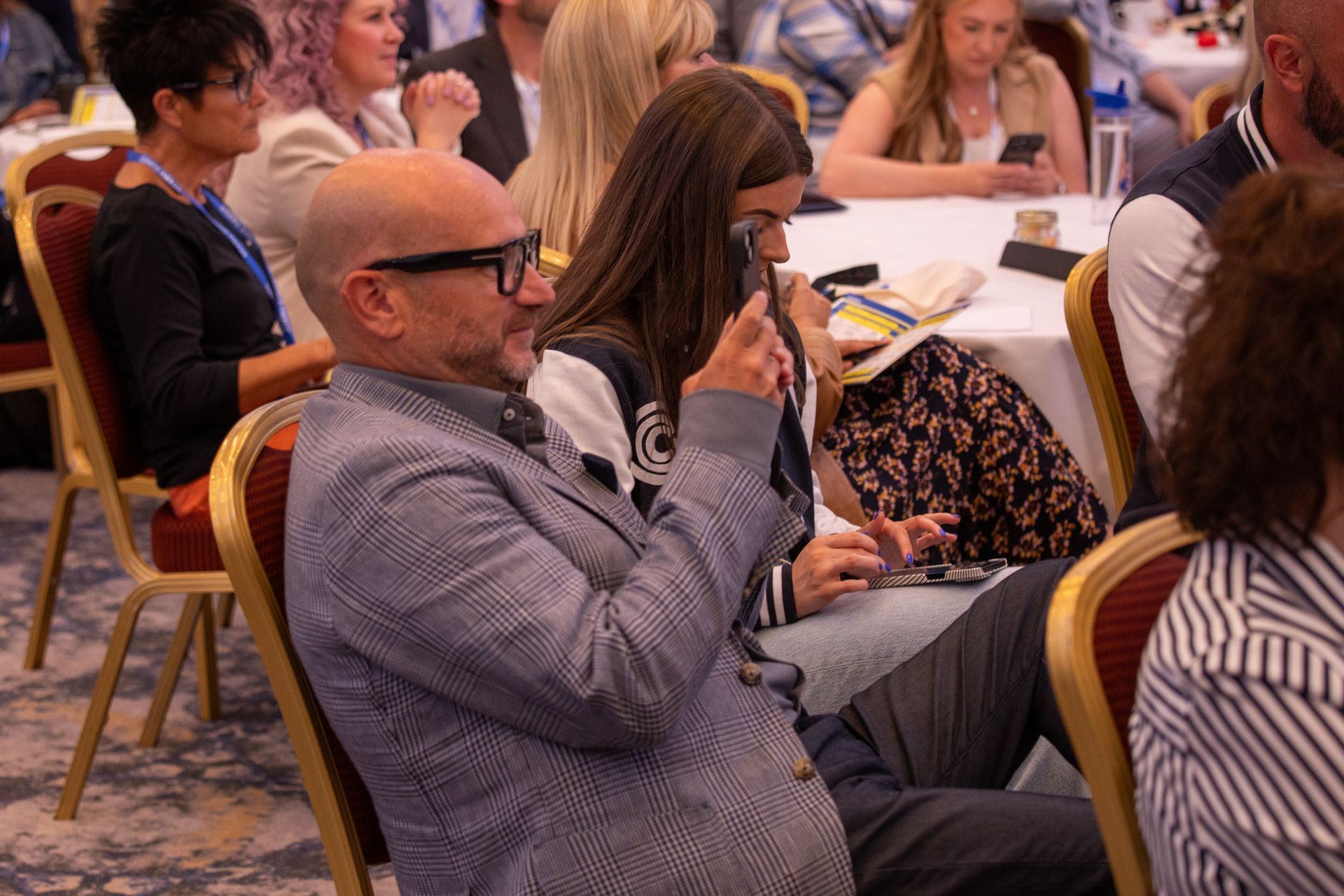 A group of people are sitting in chairs at a conference.