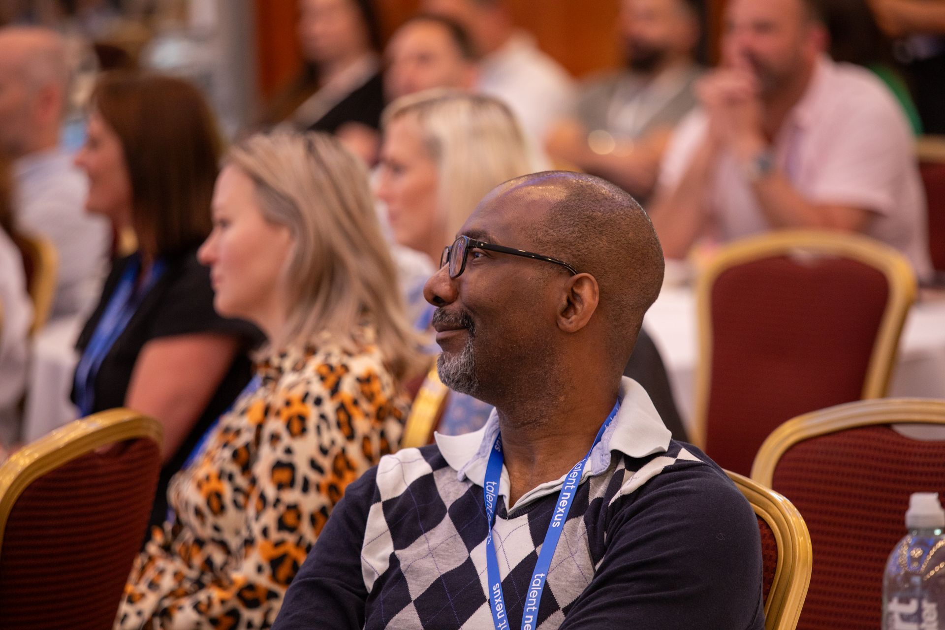A group of people are sitting in chairs at a conference.