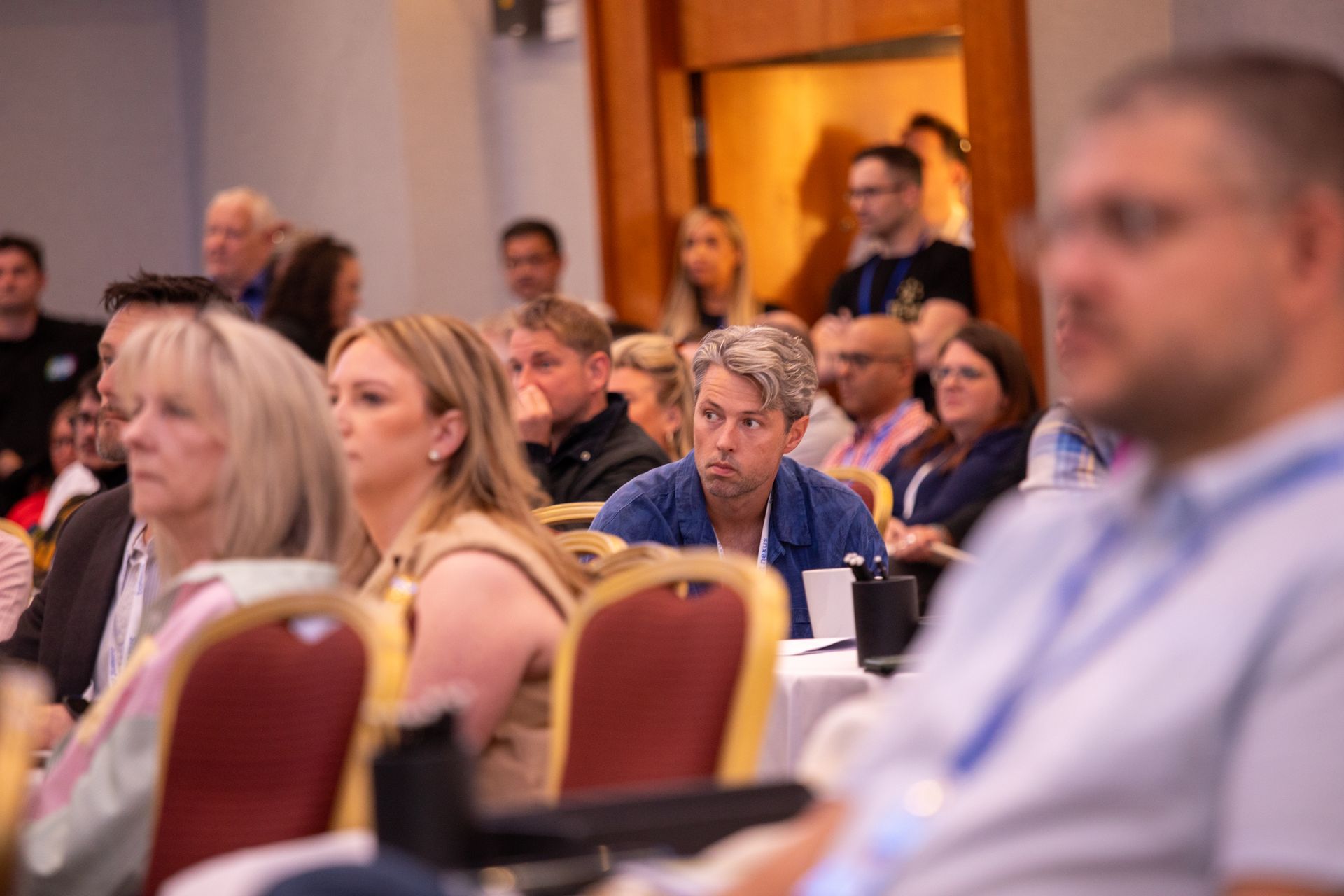 A group of people are sitting in chairs at a conference.