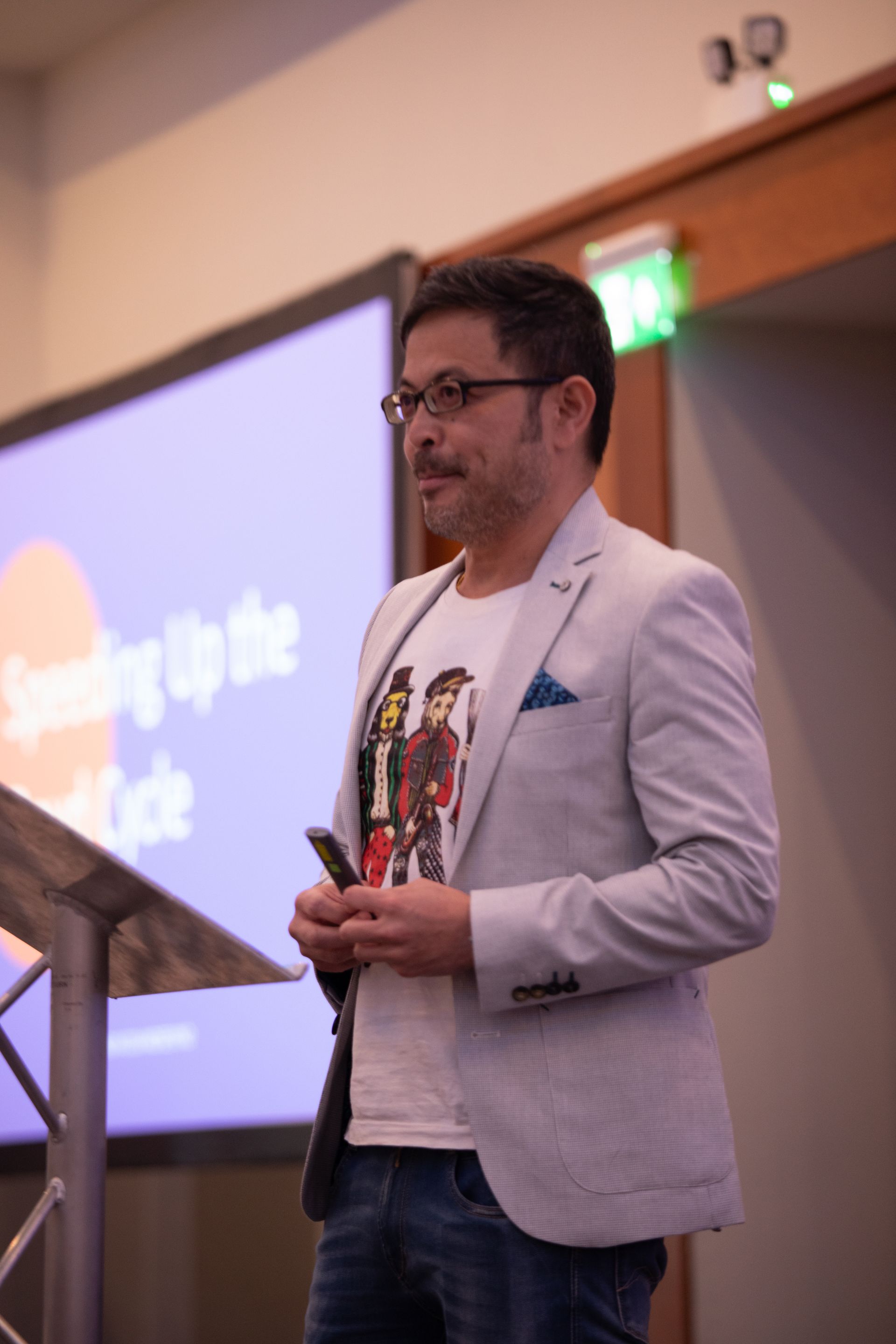 A man in a suit is standing at a podium giving a presentation