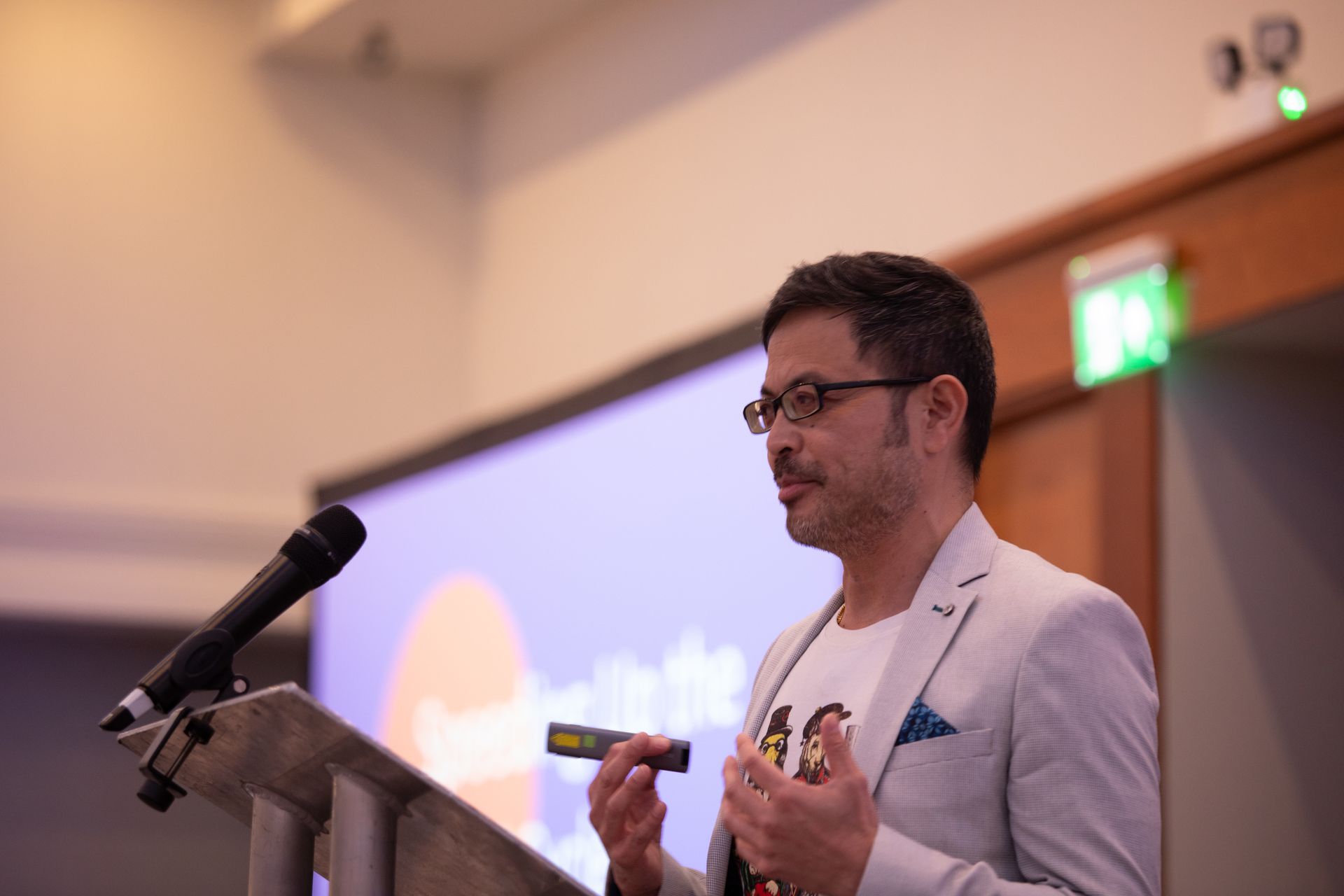 A man is giving a speech at a podium in front of a microphone.