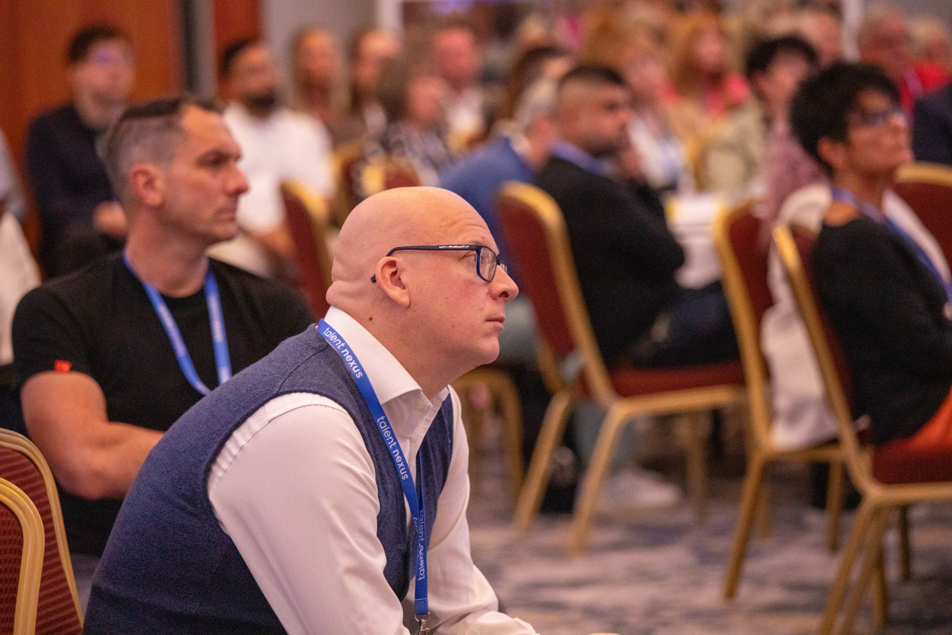 A group of people are sitting in chairs at a conference.