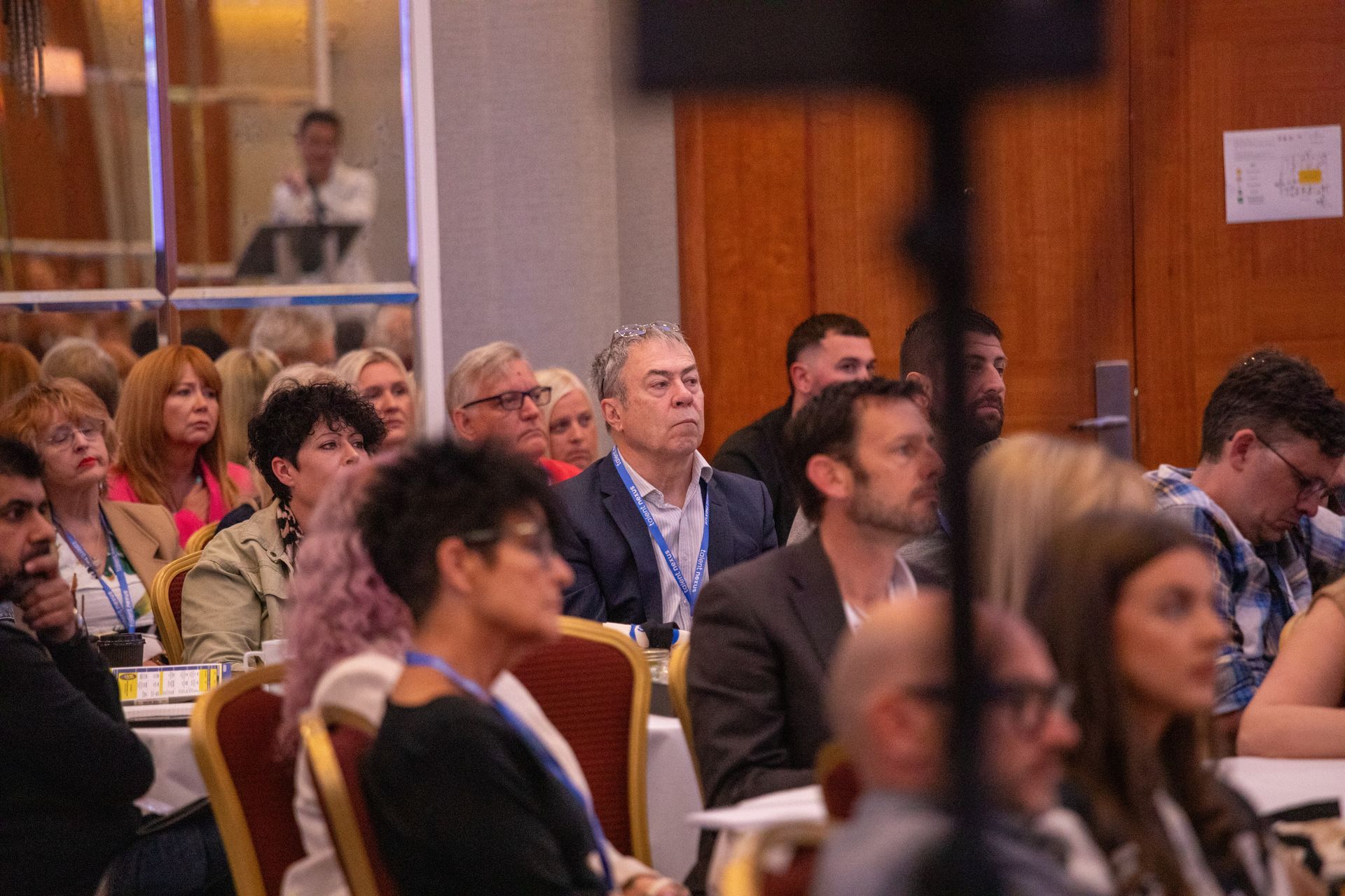 A group of people are sitting in chairs at a conference.