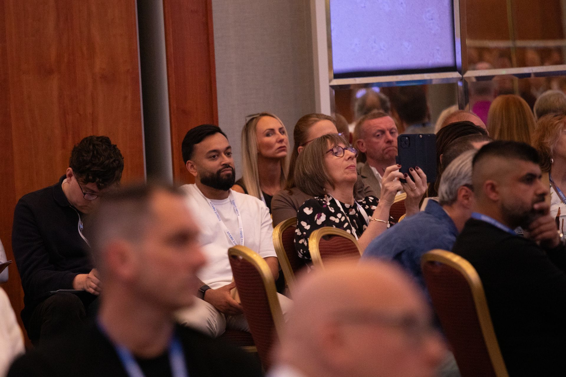 A group of people are sitting in chairs at a conference.