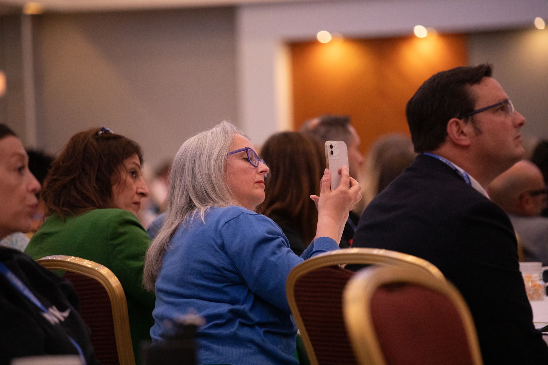 A group of people are sitting in chairs at a conference.