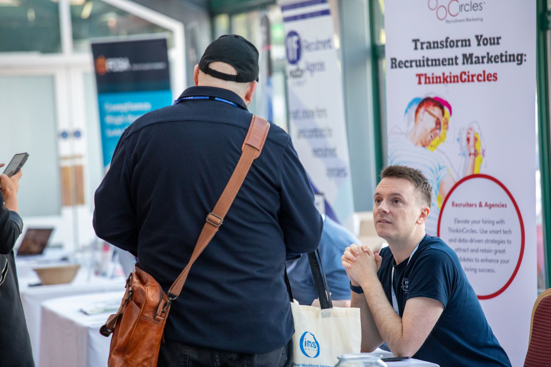 A man is talking to another man at a job fair.