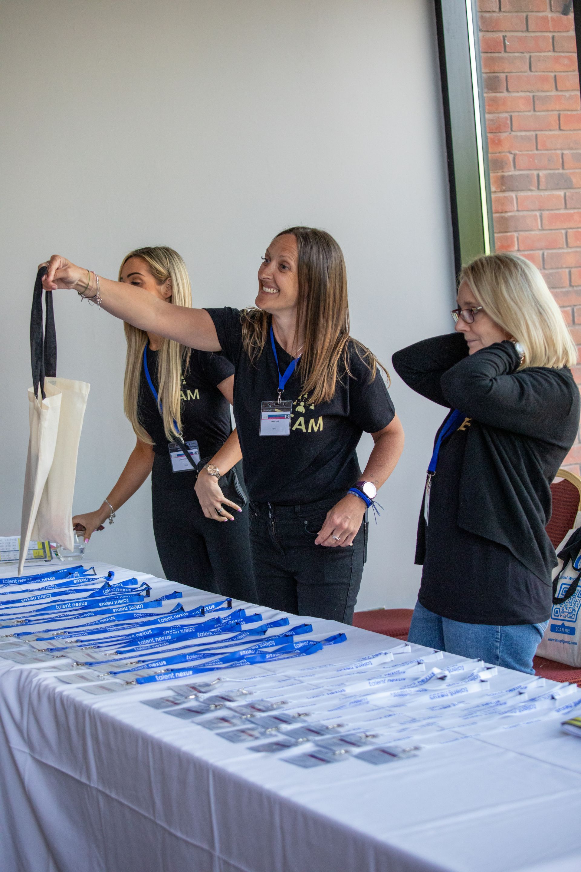 A group of women are standing around a table holding umbrellas.