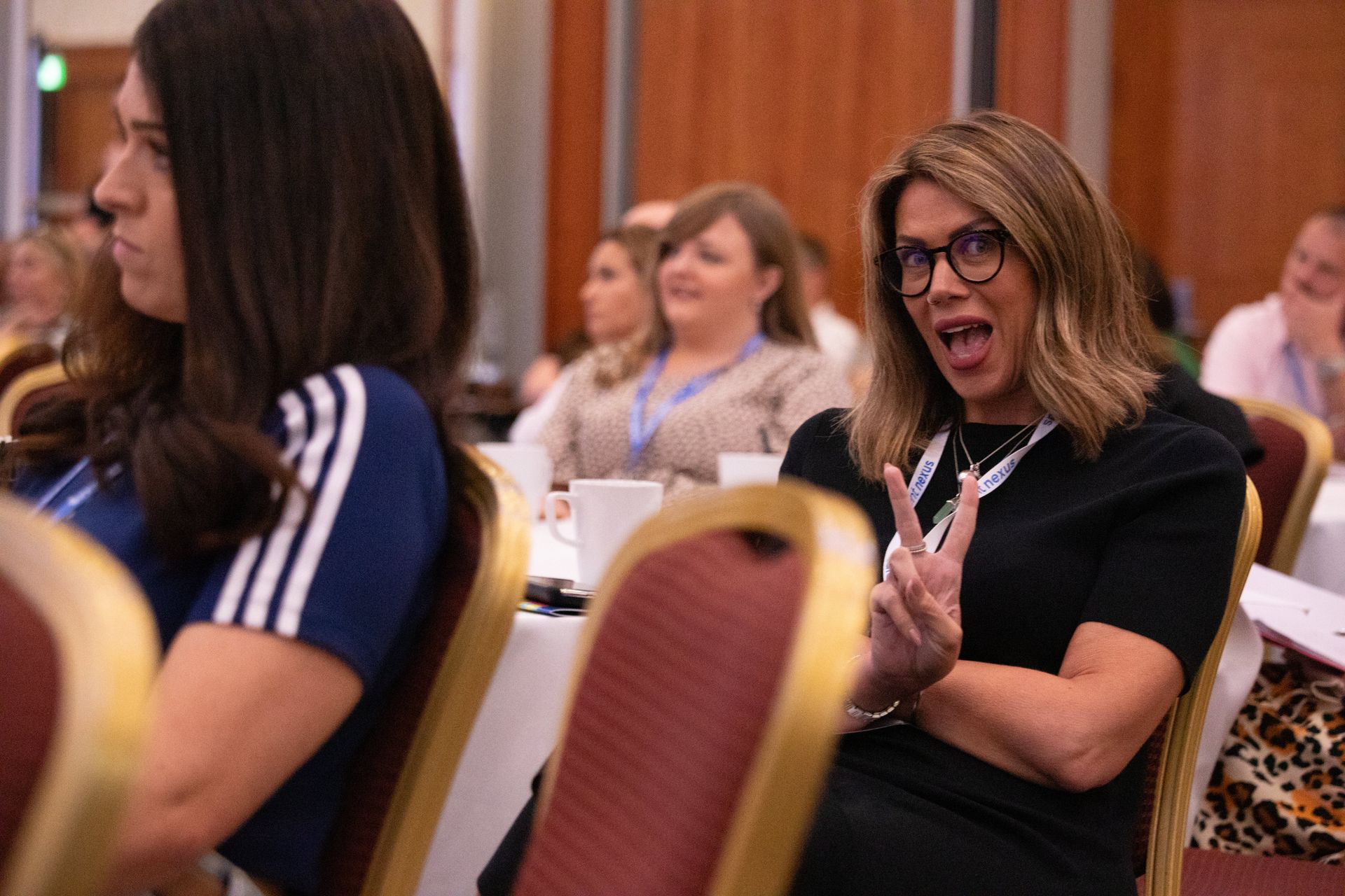 A group of women are sitting in chairs at a conference.