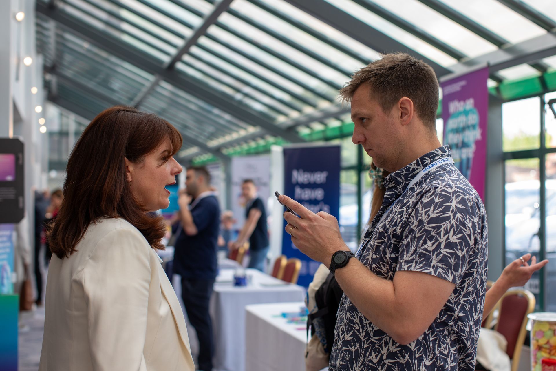 A man and a woman are talking to each other at a job fair.