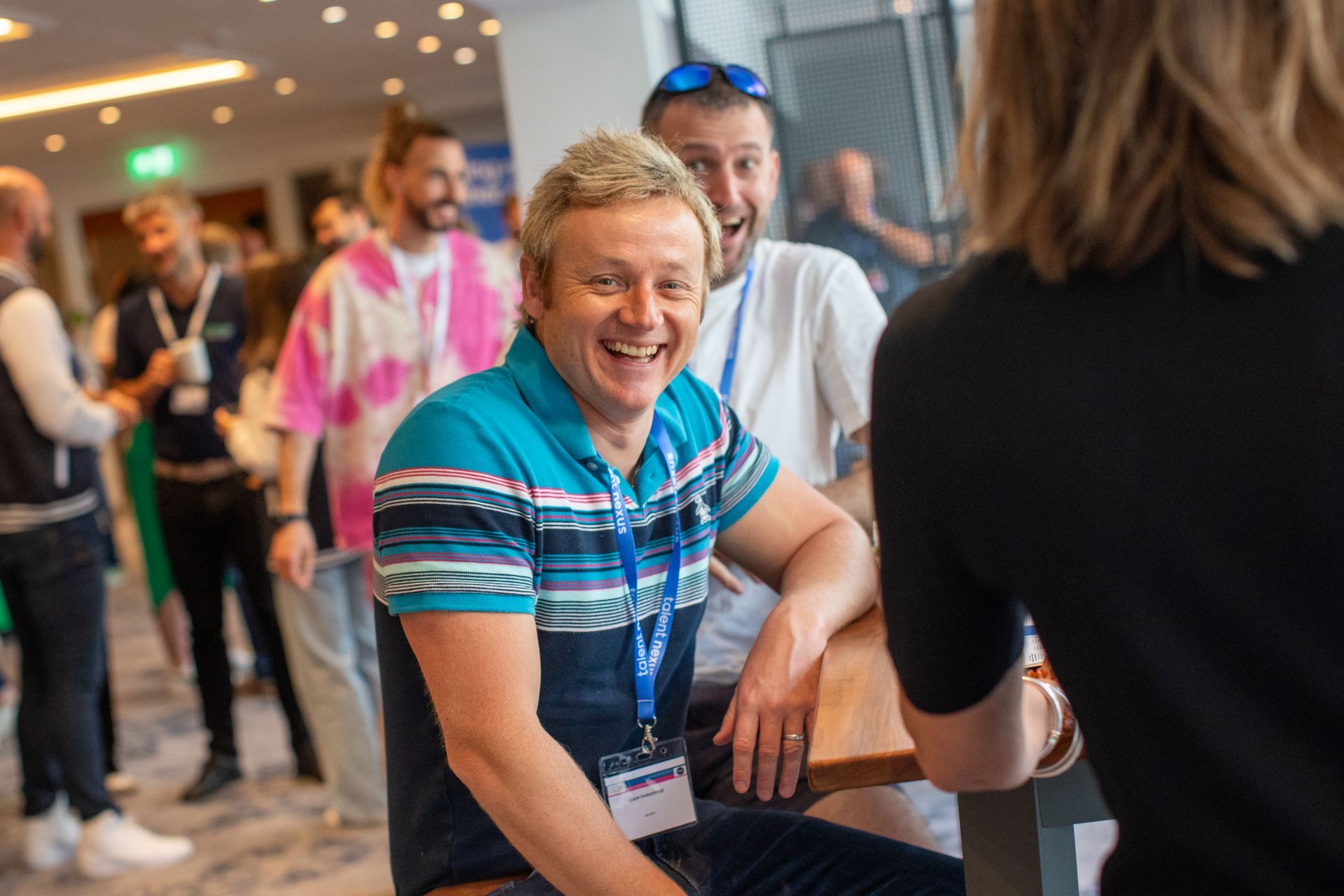 A man is sitting at a table talking to a woman.