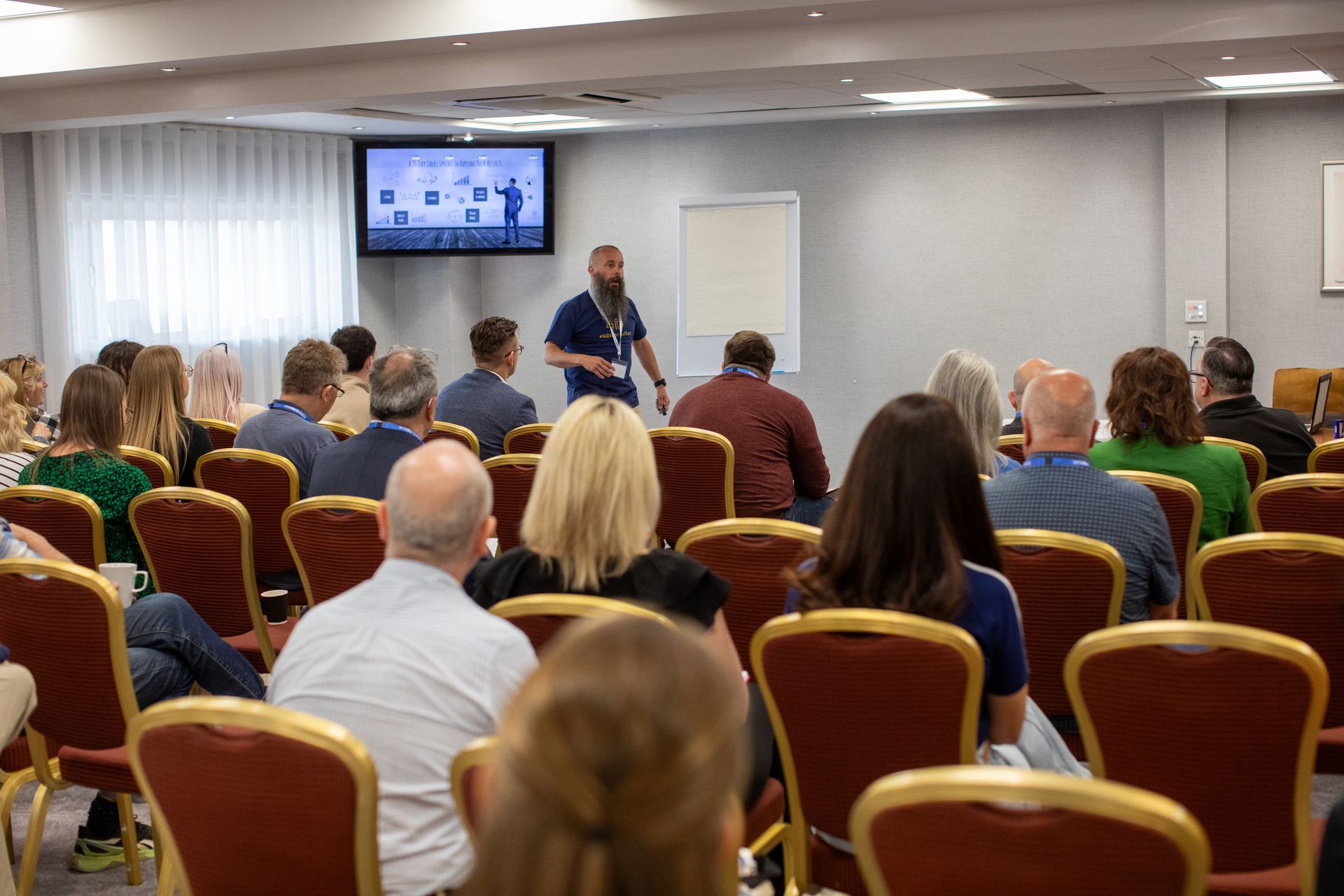 A man is giving a presentation to a group of people in a conference room.