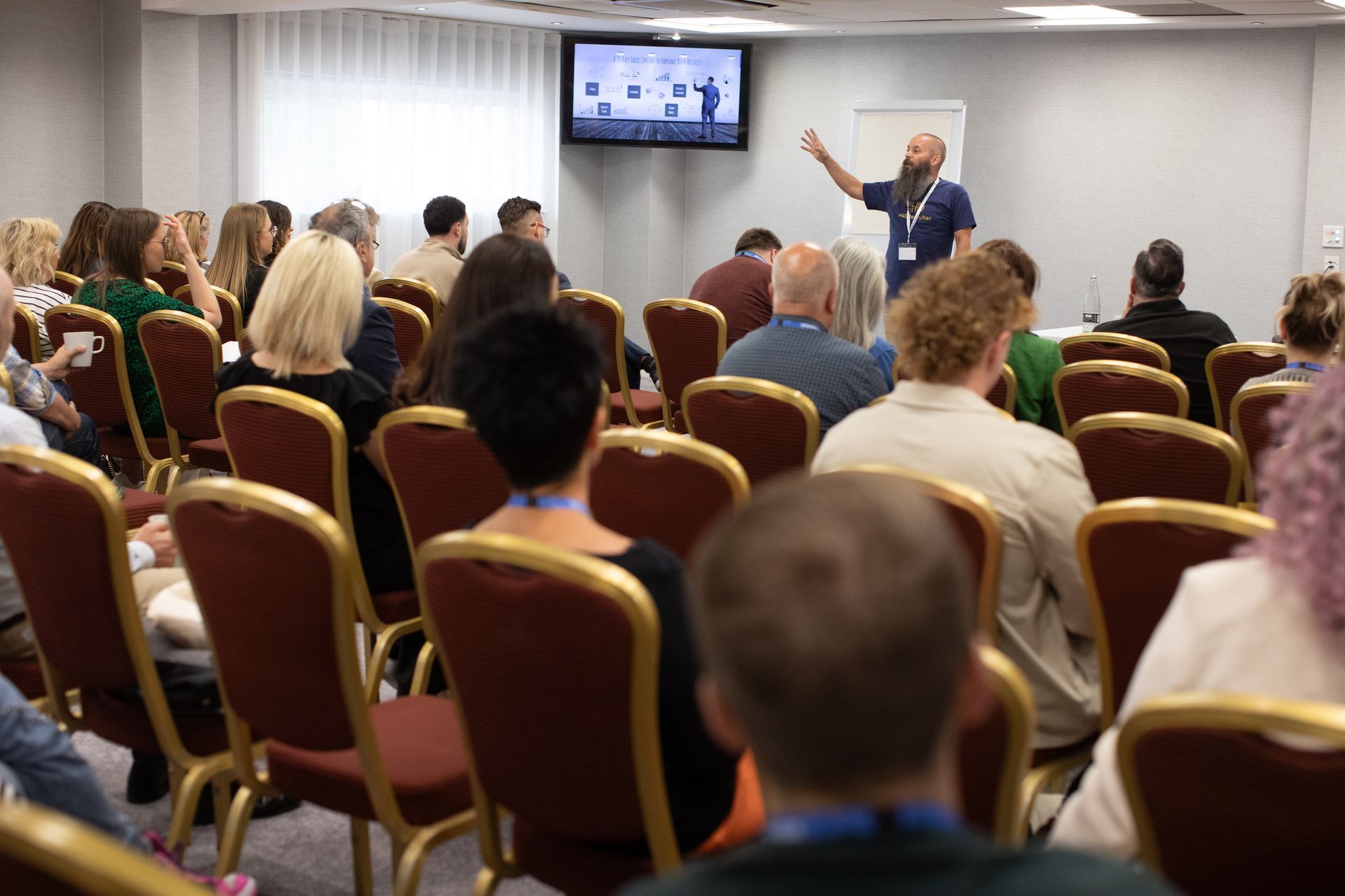 A man is giving a presentation to a group of people in a conference room.