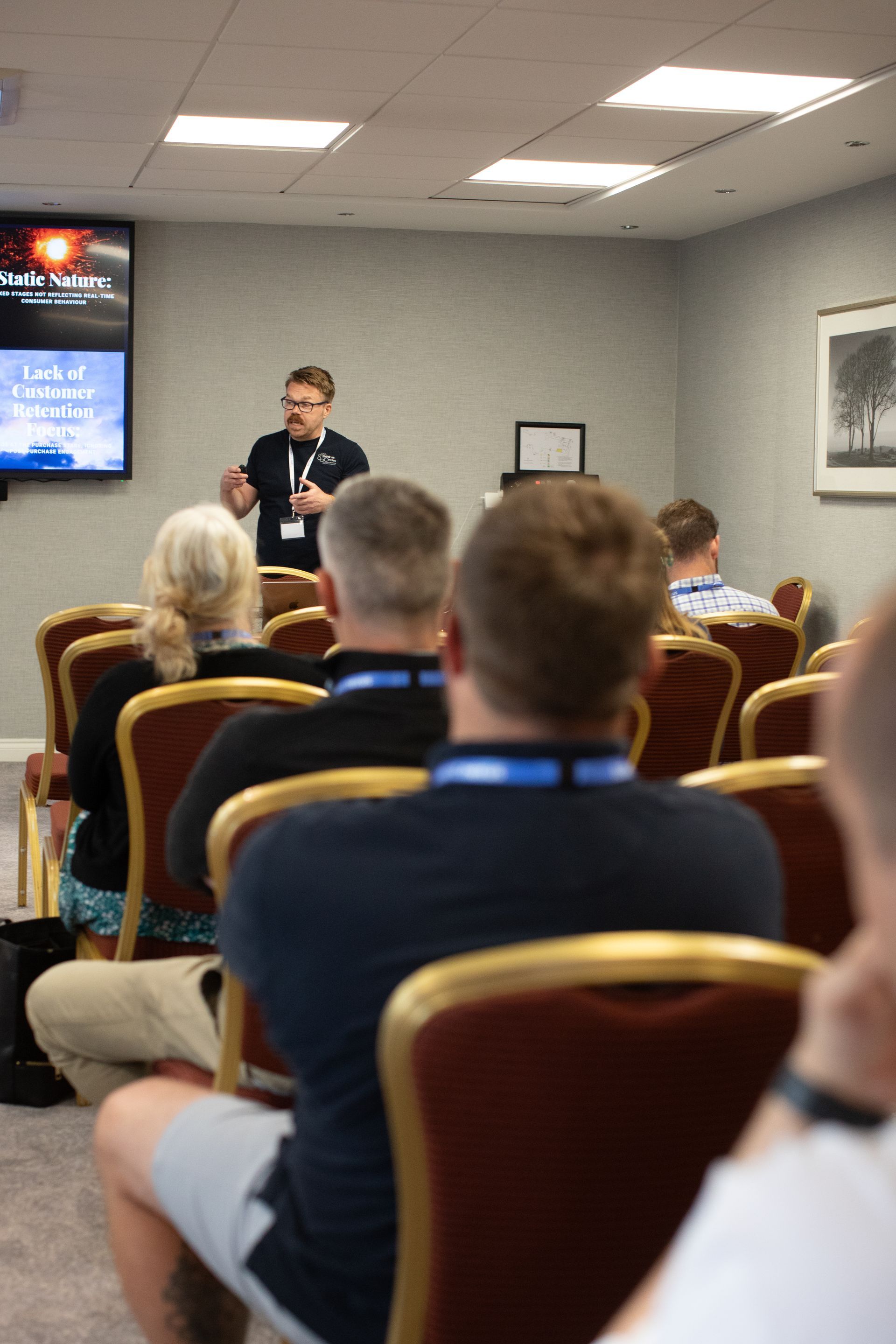 A man is giving a presentation to a group of people in a conference room.
