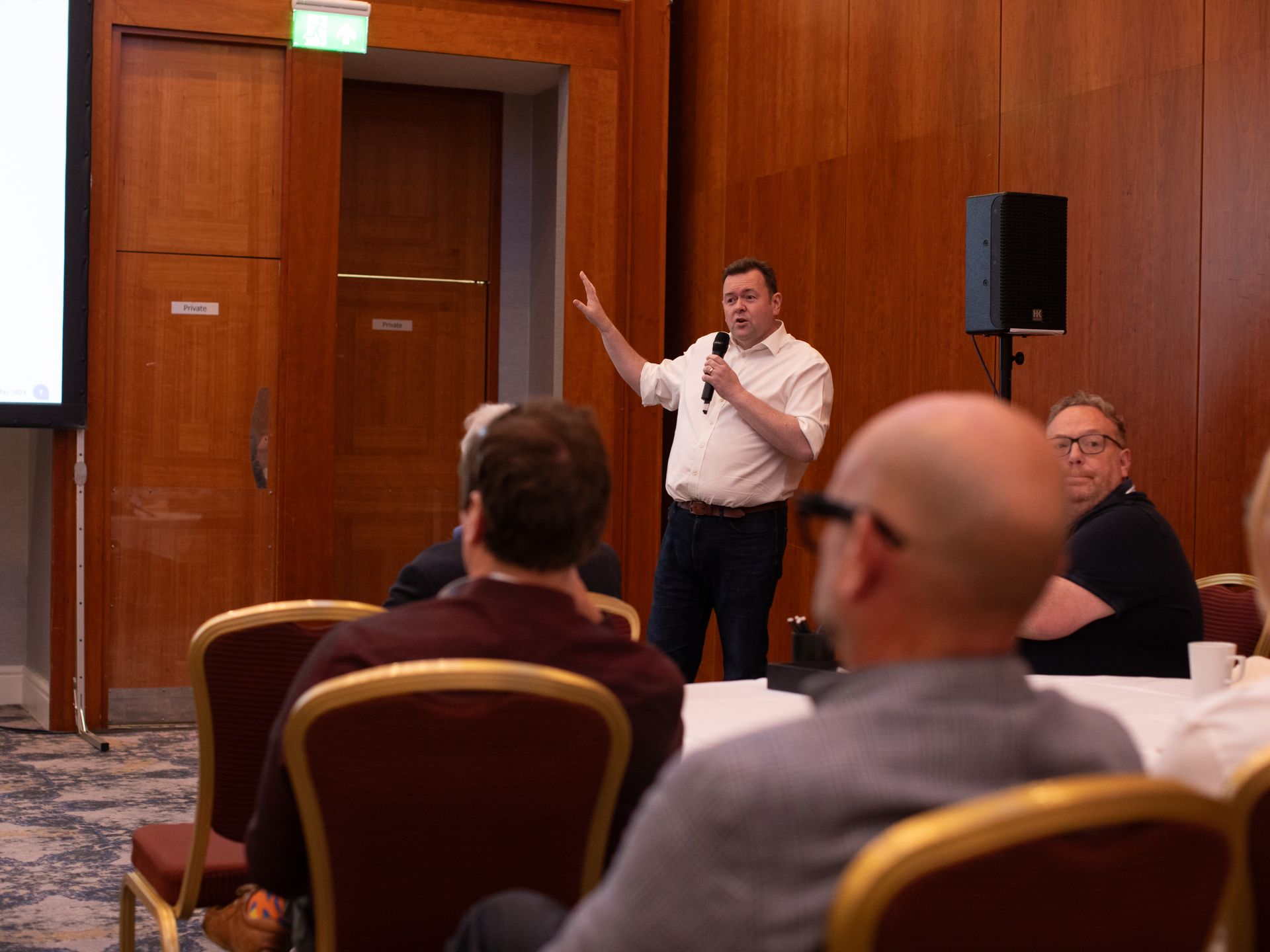 A man is giving a presentation to a group of people in a conference room.