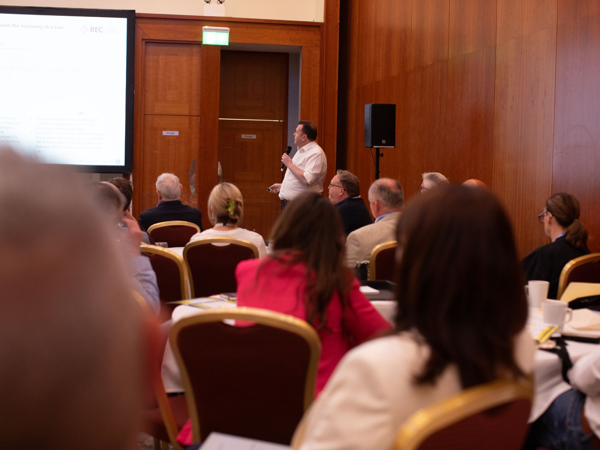 A man is giving a presentation to a group of people in a conference room.