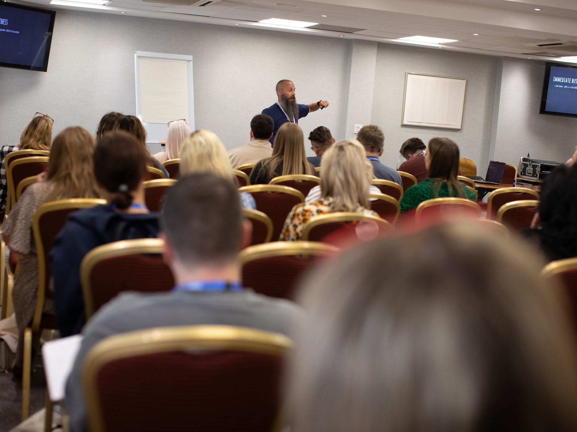 A man is giving a presentation to a group of people in a conference room.