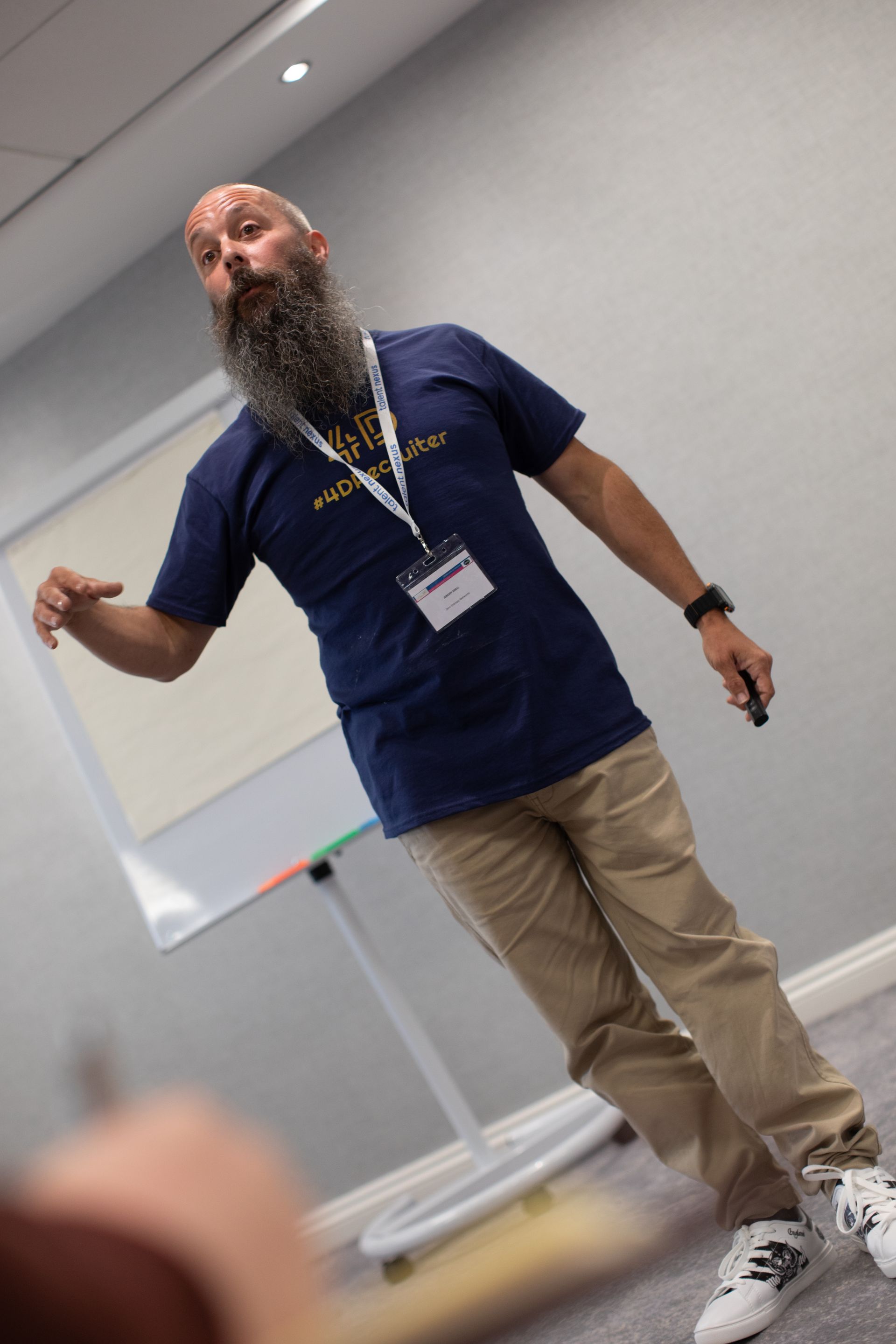 A man with a beard is giving a presentation in a room.
